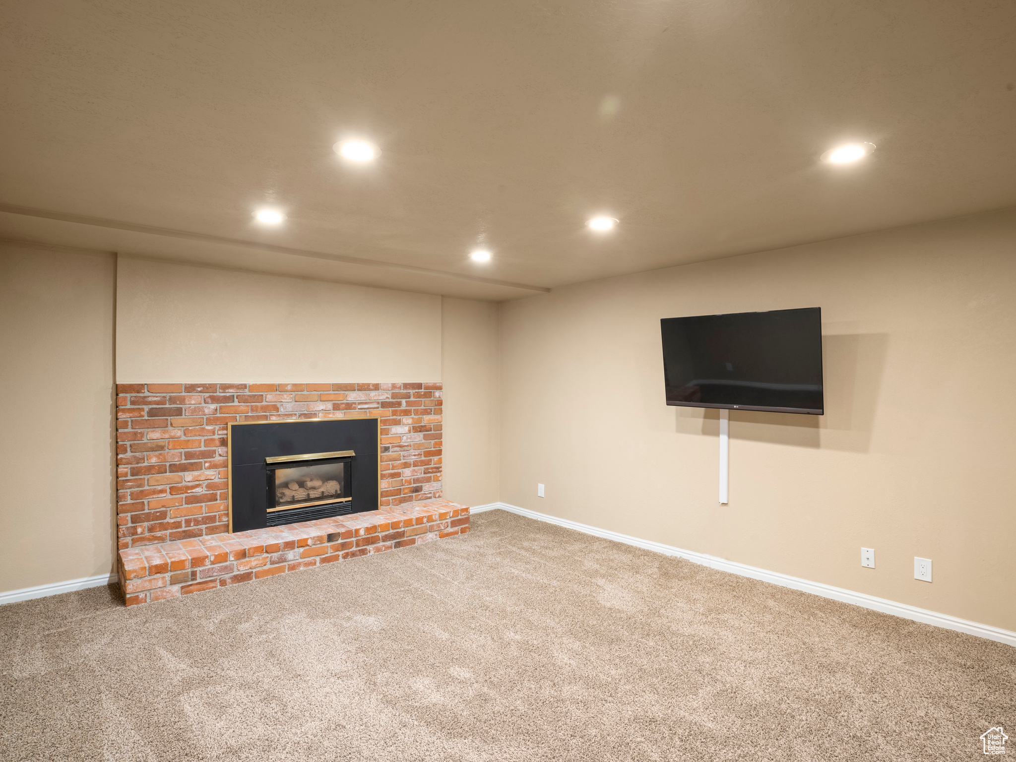 Unfurnished living room with carpet flooring and a fireplace