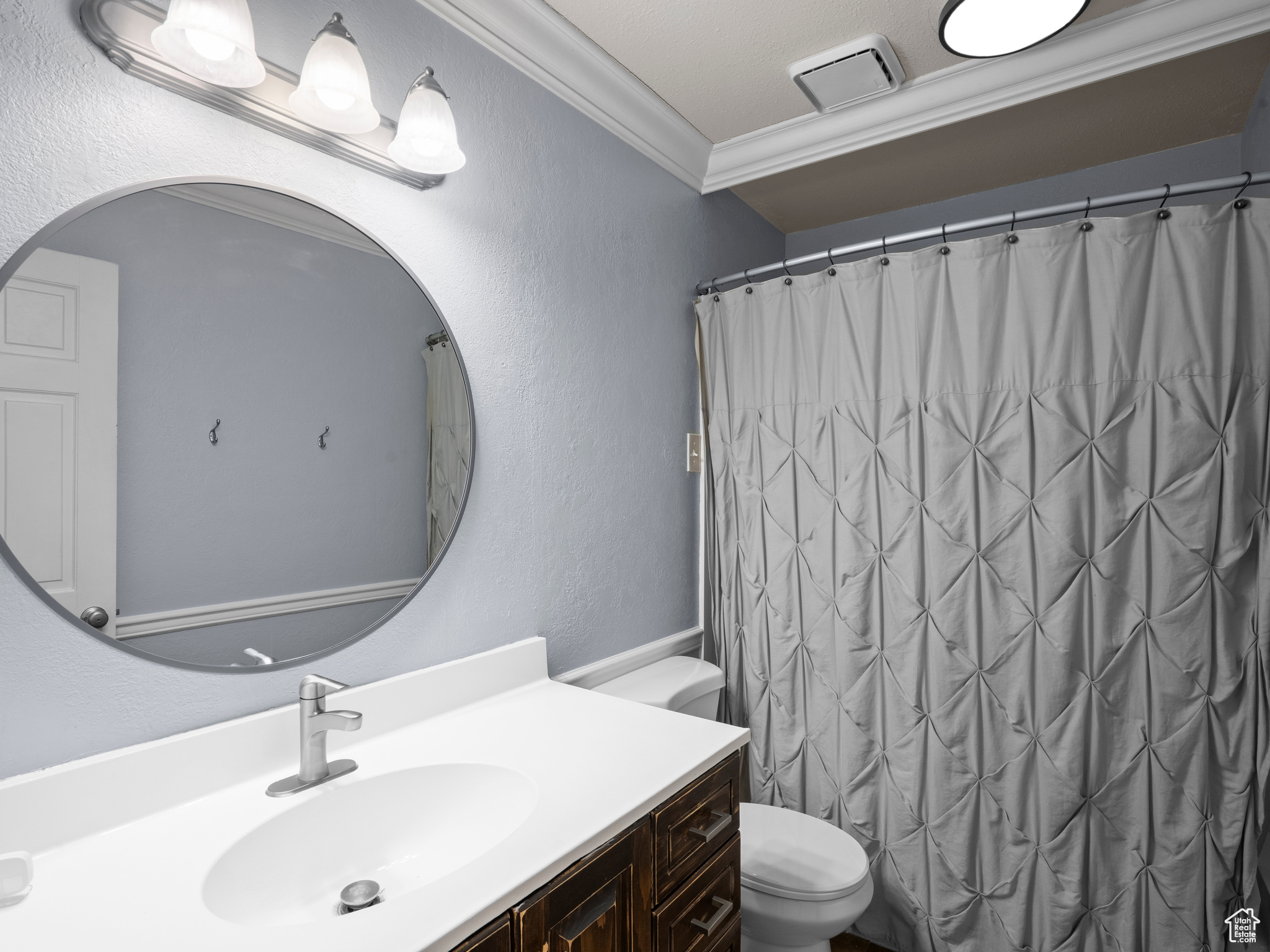 Bathroom featuring ornamental molding, toilet, and vanity