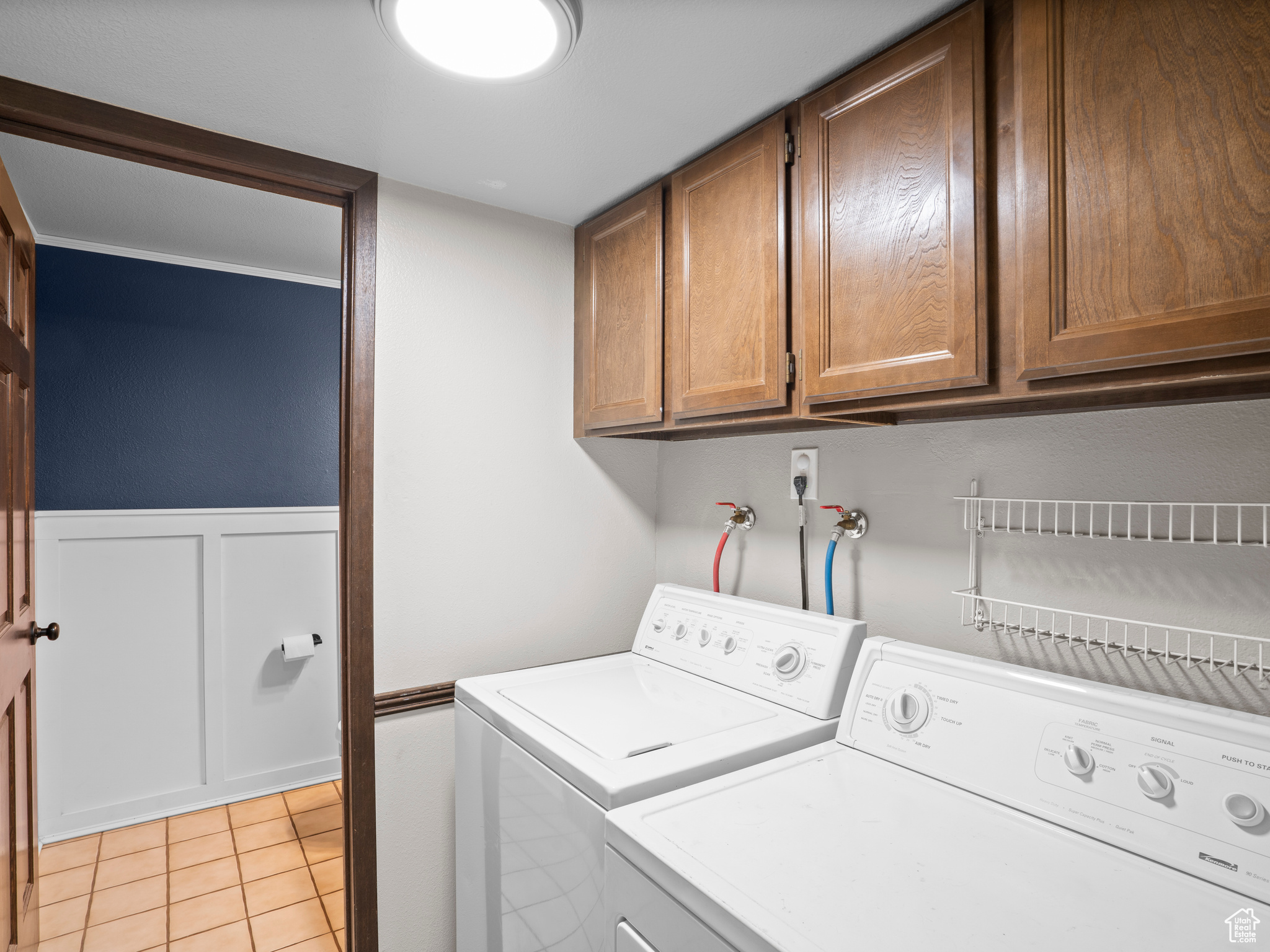 Laundry room featuring cabinets, light tile floors, hookup for a washing machine, and washer and clothes dryer