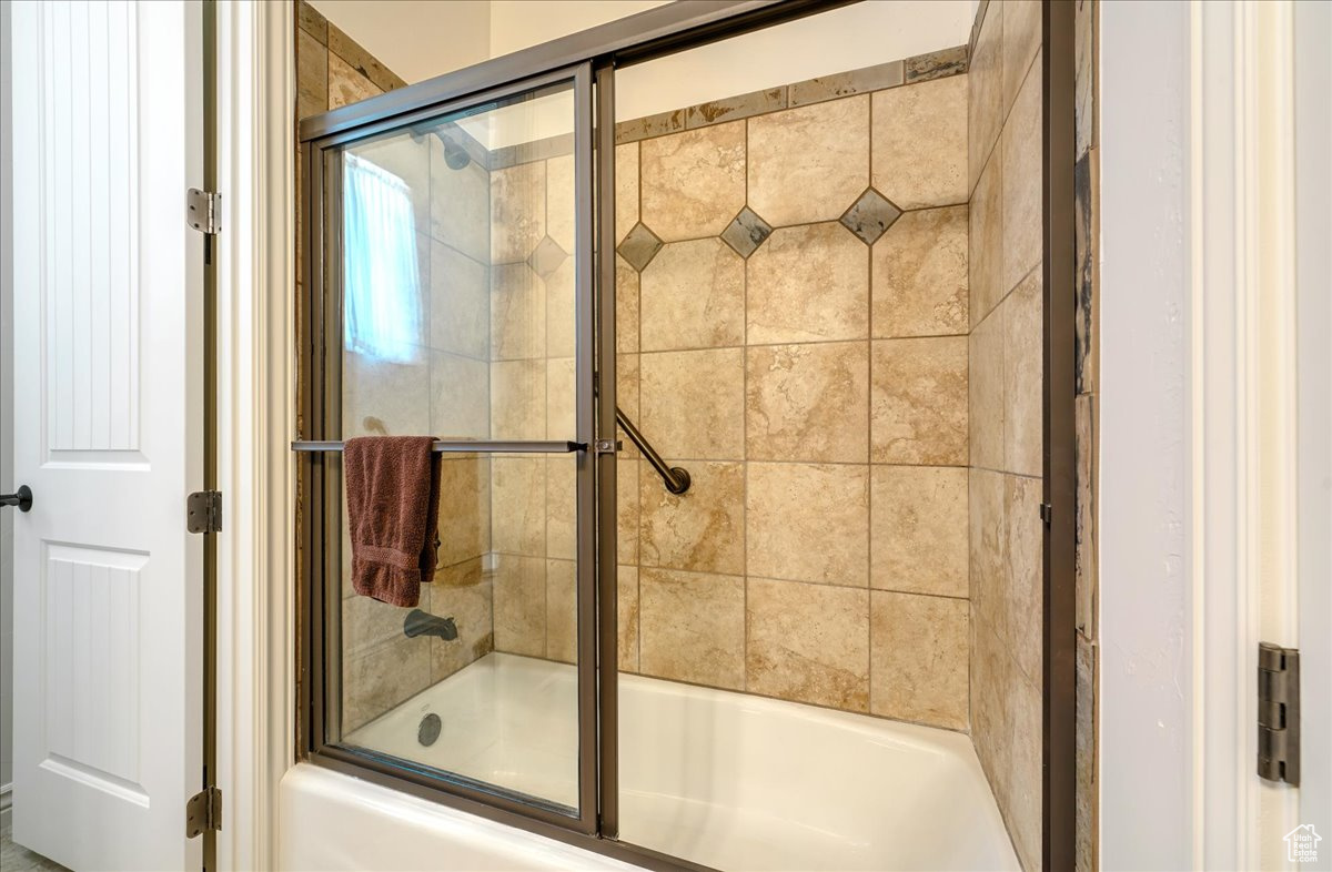 Bathroom featuring shower / bath combination with glass door