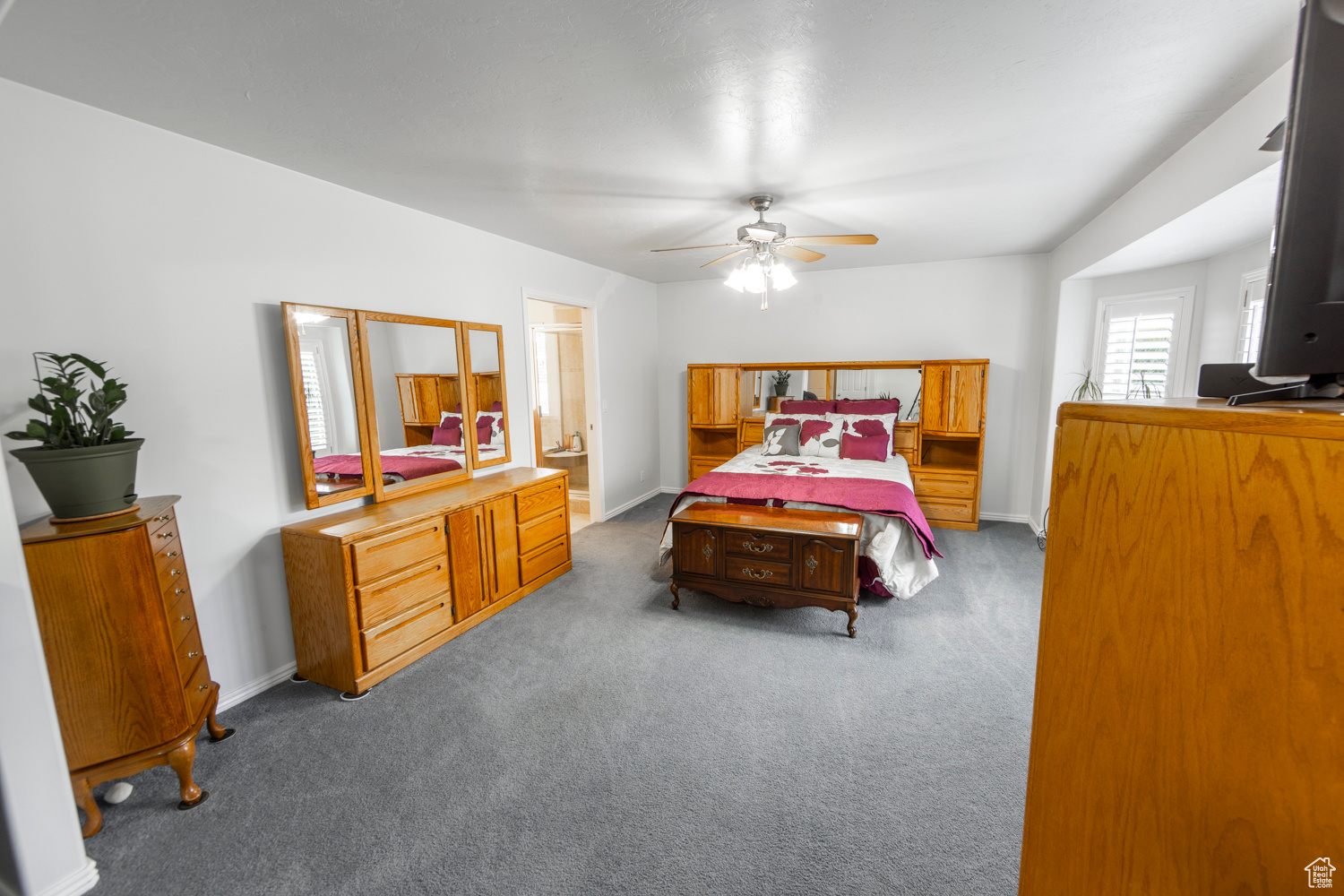 Spacious Master bedroom with ceiling fan and carpet