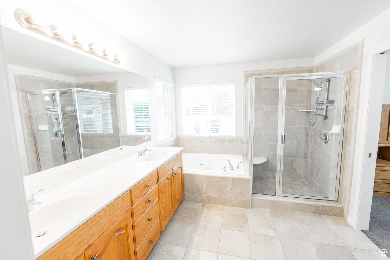 Large Master bathroom featuring oversized vanity, plus walk in shower, tile floors, and dual sinks