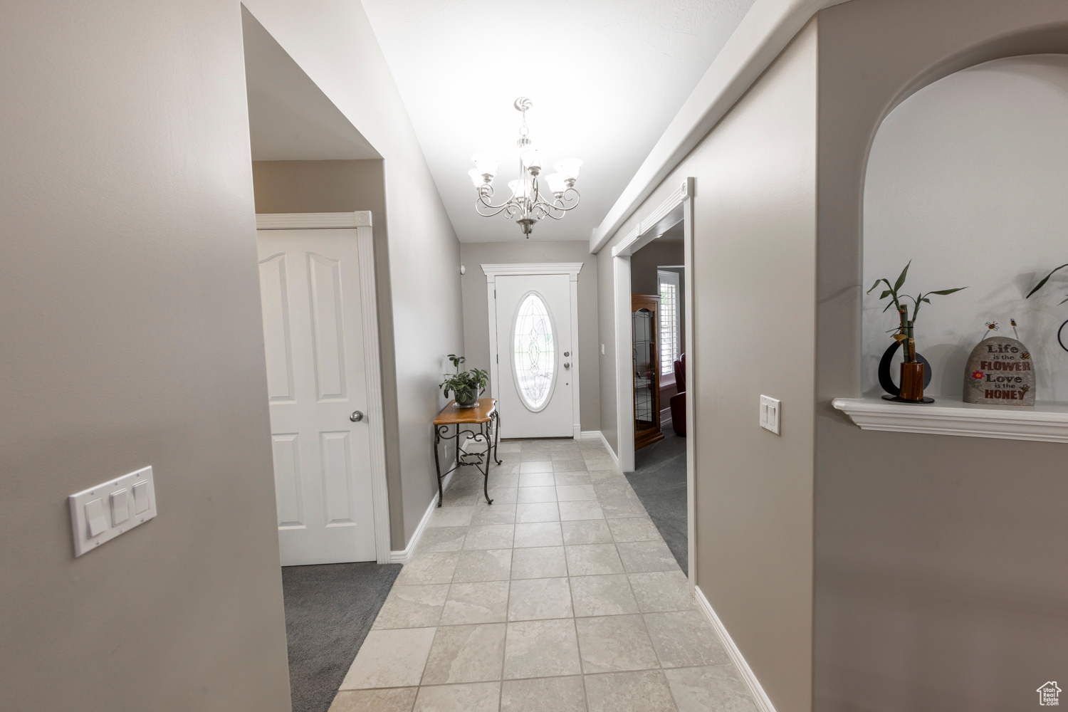 Entryway featuring light tile floors and a chandelier