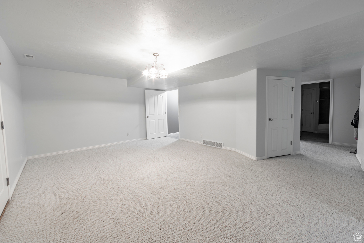 Bonus room  or Family room or Theater room Downstairs with a chandelier and carpet
