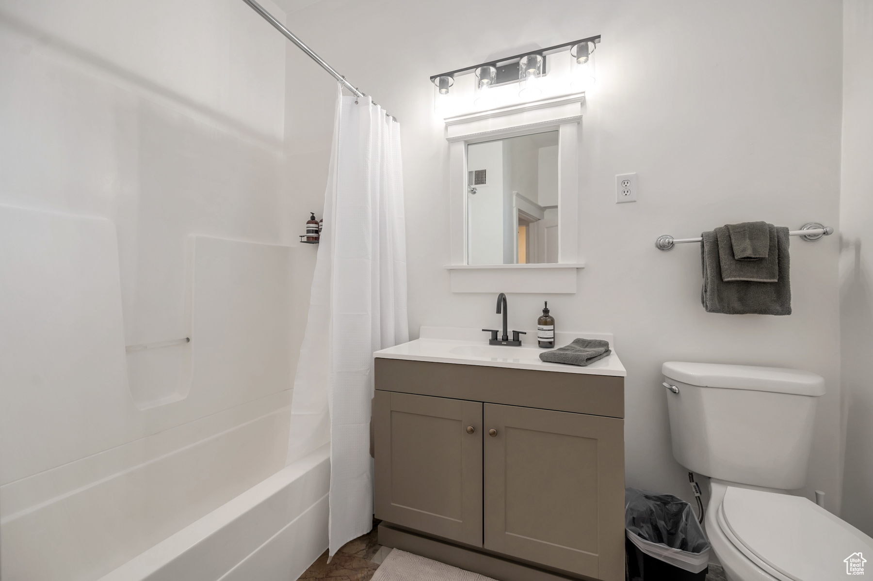 Full bathroom with vanity, shower / tub combo, tile floors, and toilet