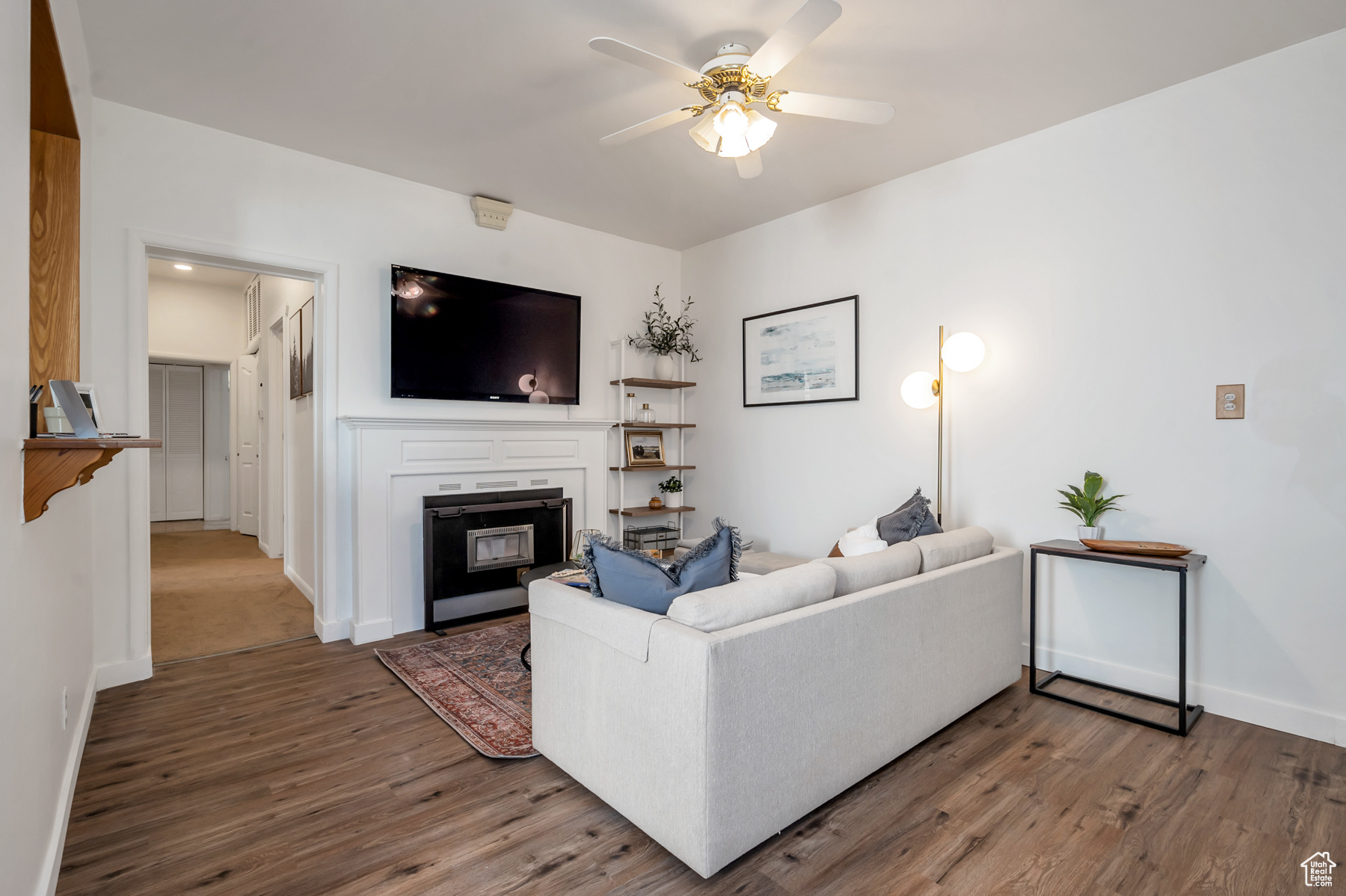 Carpeted living room featuring ceiling fan