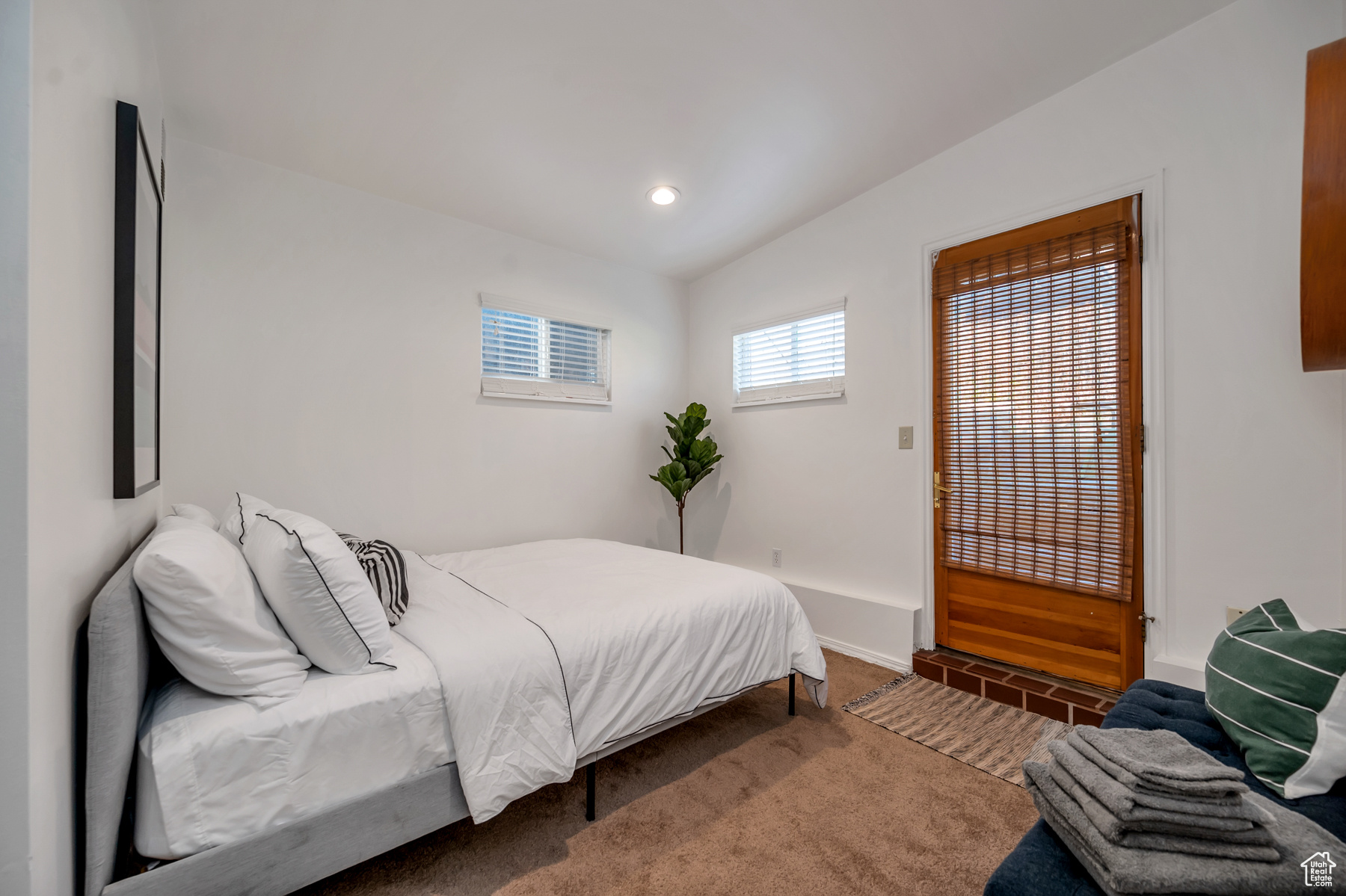 Bedroom featuring lofted ceiling and carpet