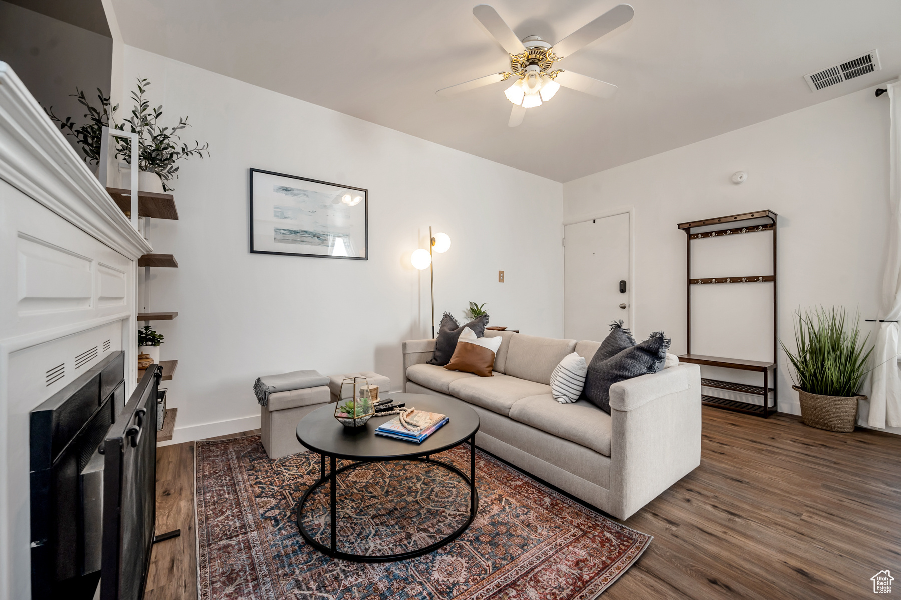 Living room featuring ceiling fan and dark wood-type flooring