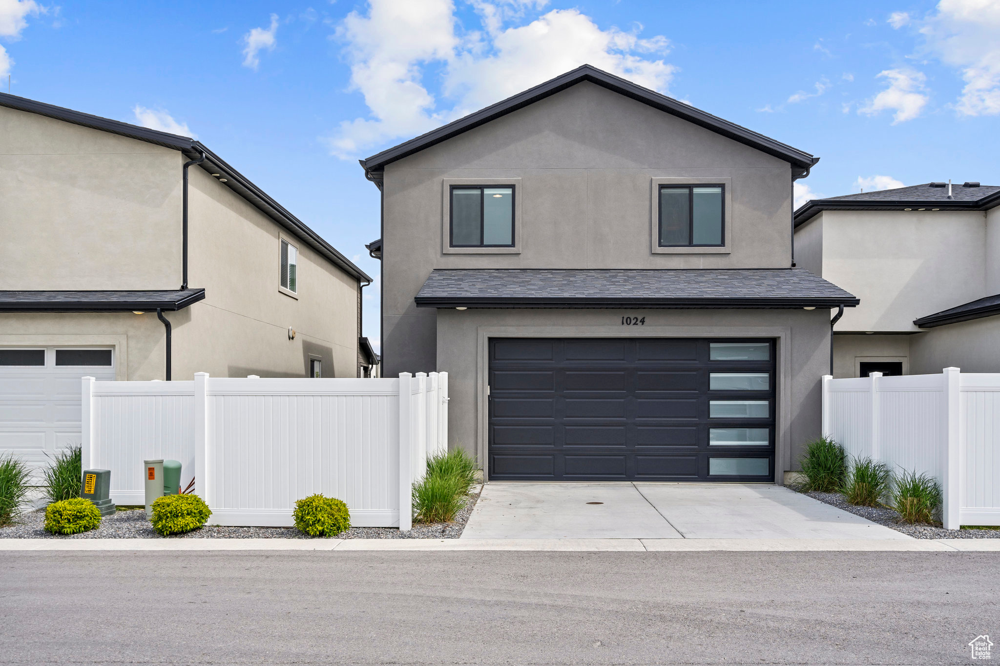 BACK VIEW OF HOME WITH DRIVEWAY AND GARAGE