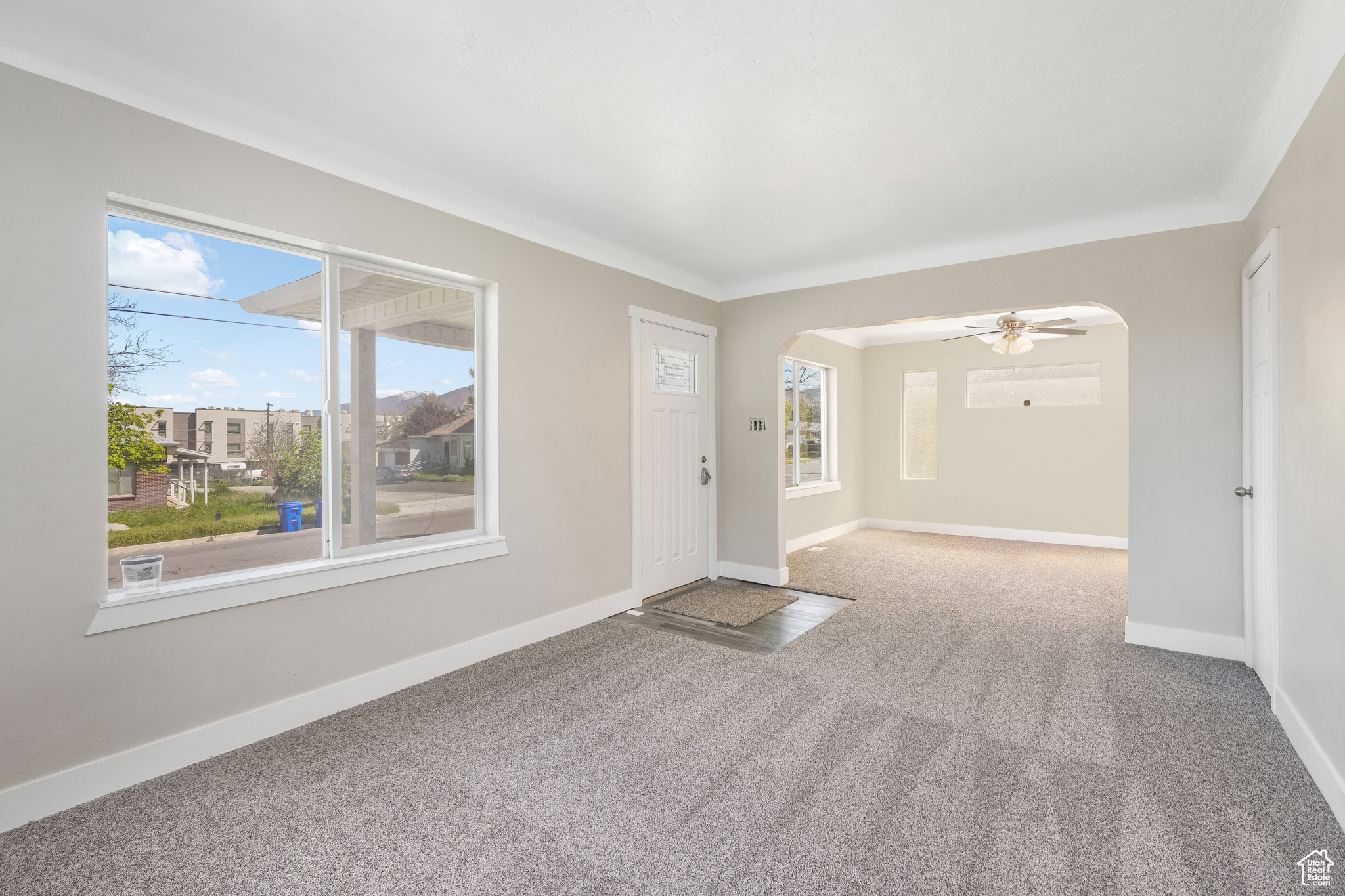 Carpeted entrance, living room with a healthy amount of sunlight