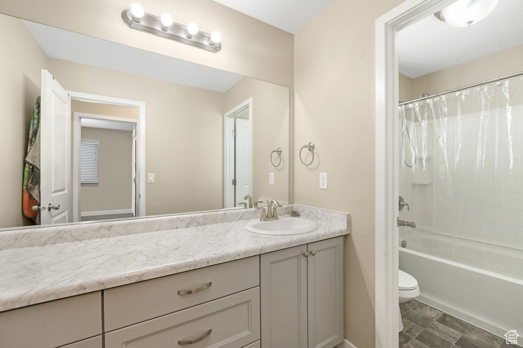 Full bathroom featuring shower / bath combo, toilet, tile floors, and vanity