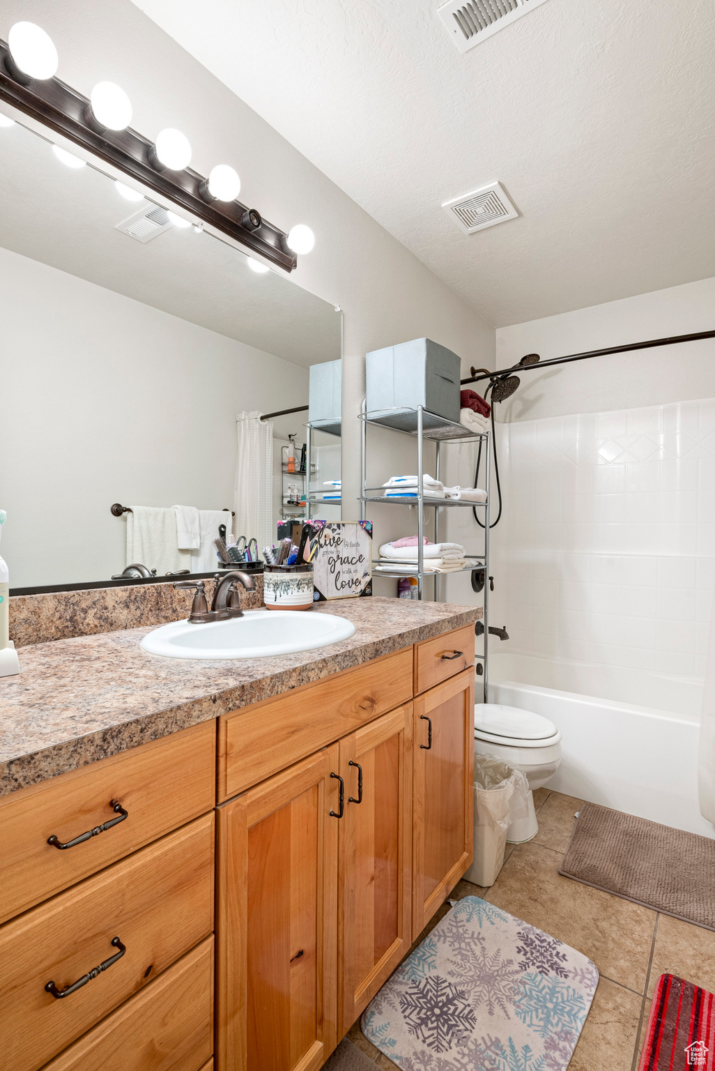 Full bathroom with shower / bath combination with curtain, tile flooring, vanity, and toilet