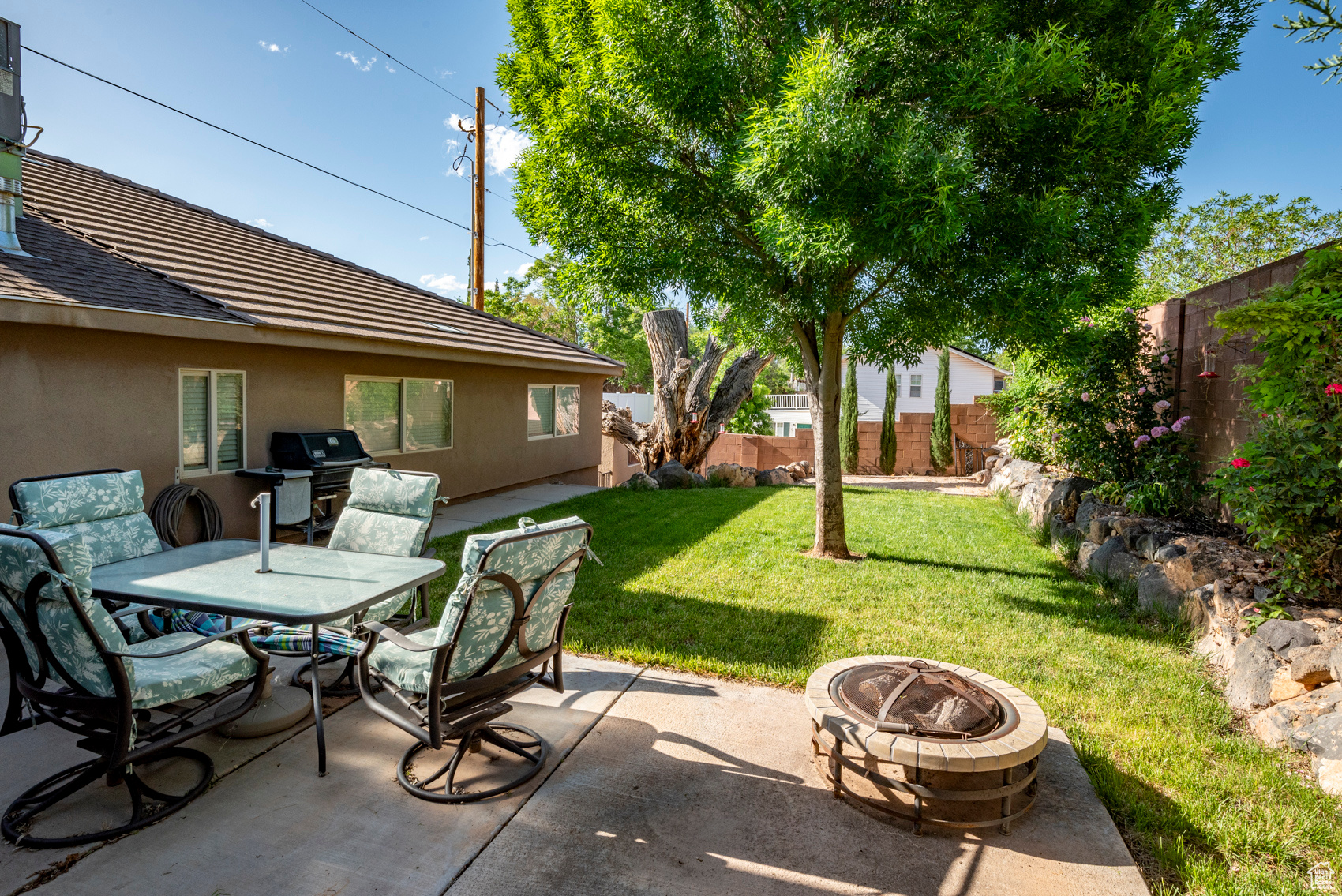 View of terrace with an outdoor fire pit and a grill