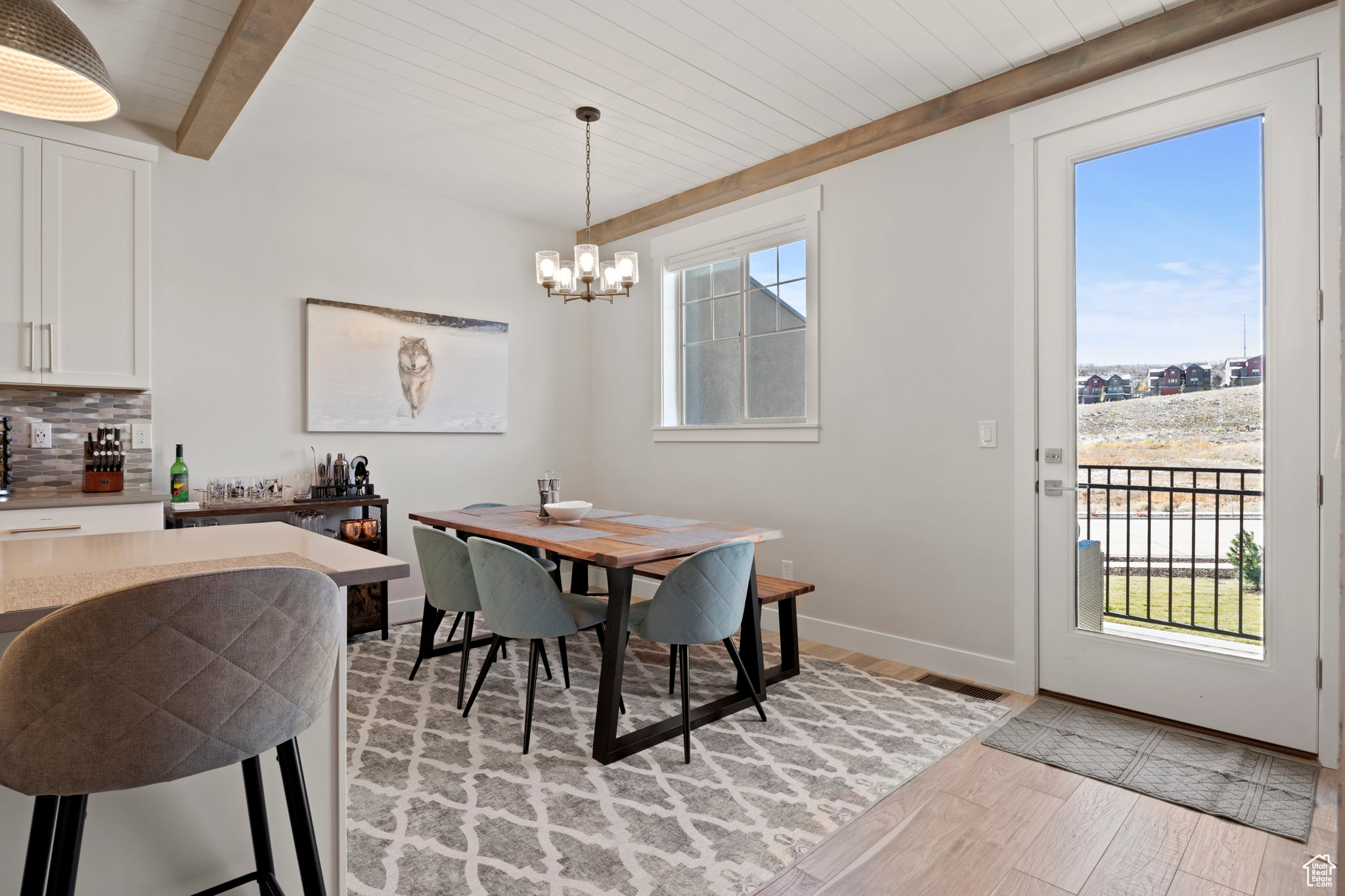 Dining room featuring a chandelier, light hardwood / wood-style floors, and beamed ceiling