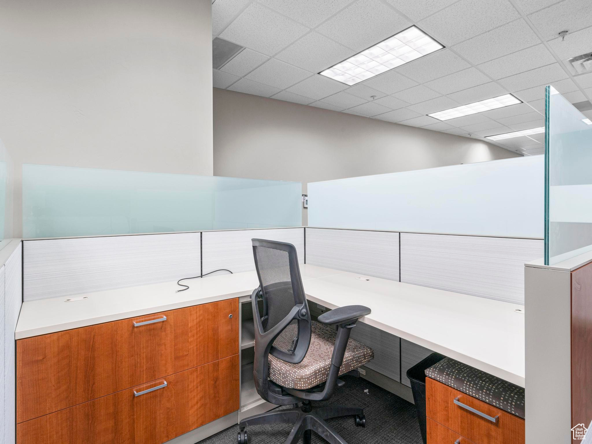 Office featuring a drop ceiling and built in desk