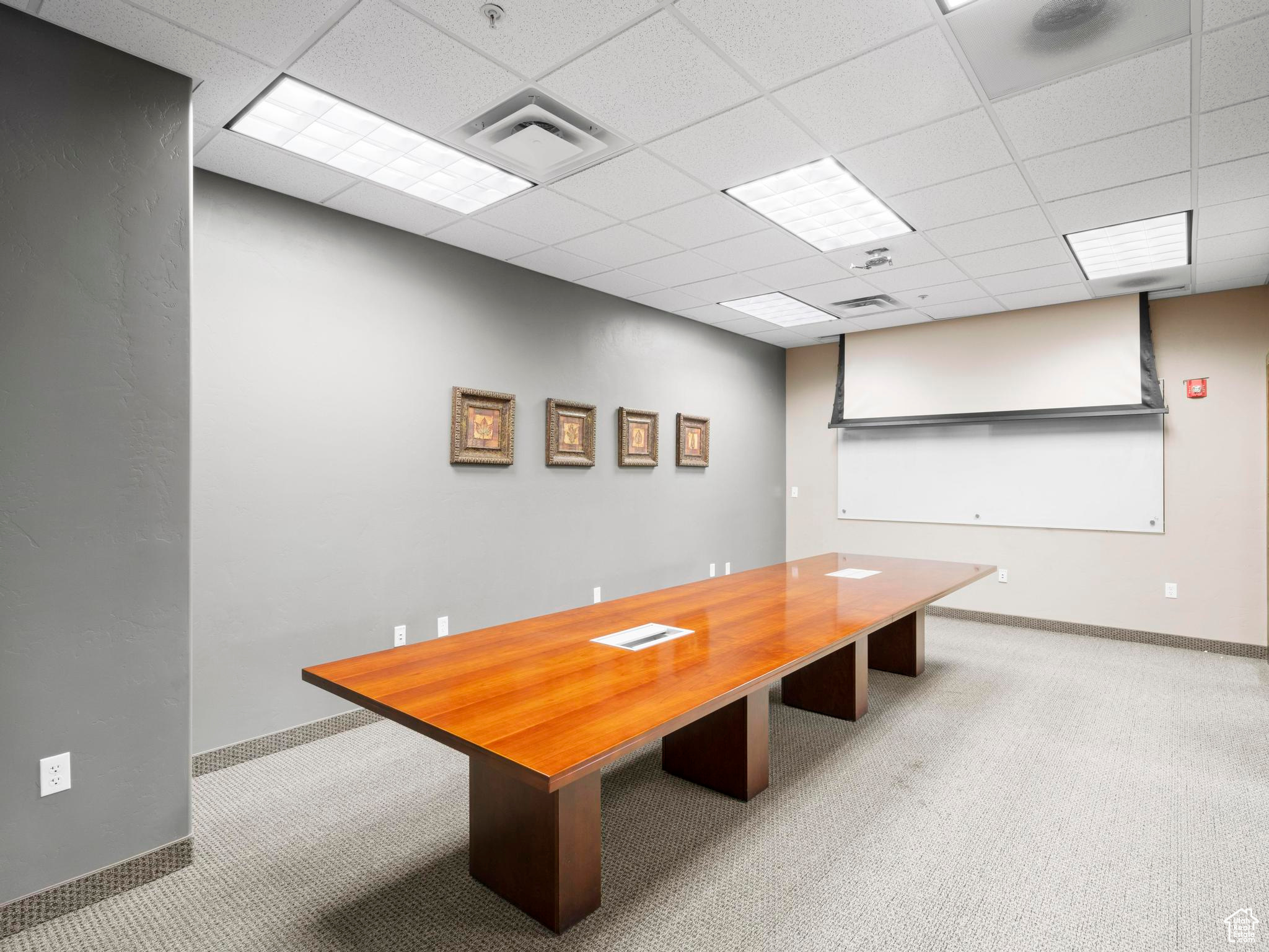 Unfurnished dining area featuring carpet and a paneled ceiling