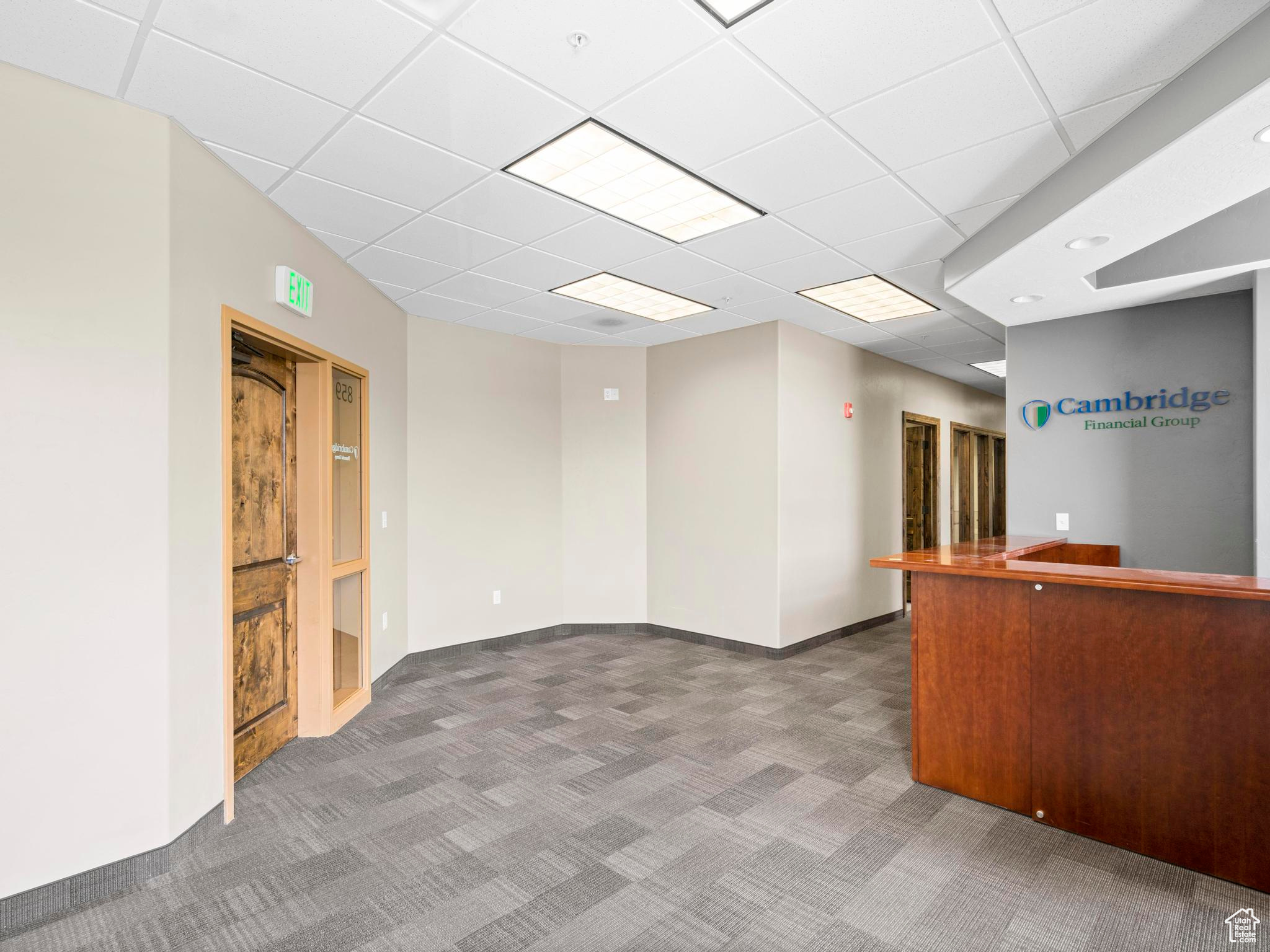 Spare room featuring a drop ceiling and carpet floors