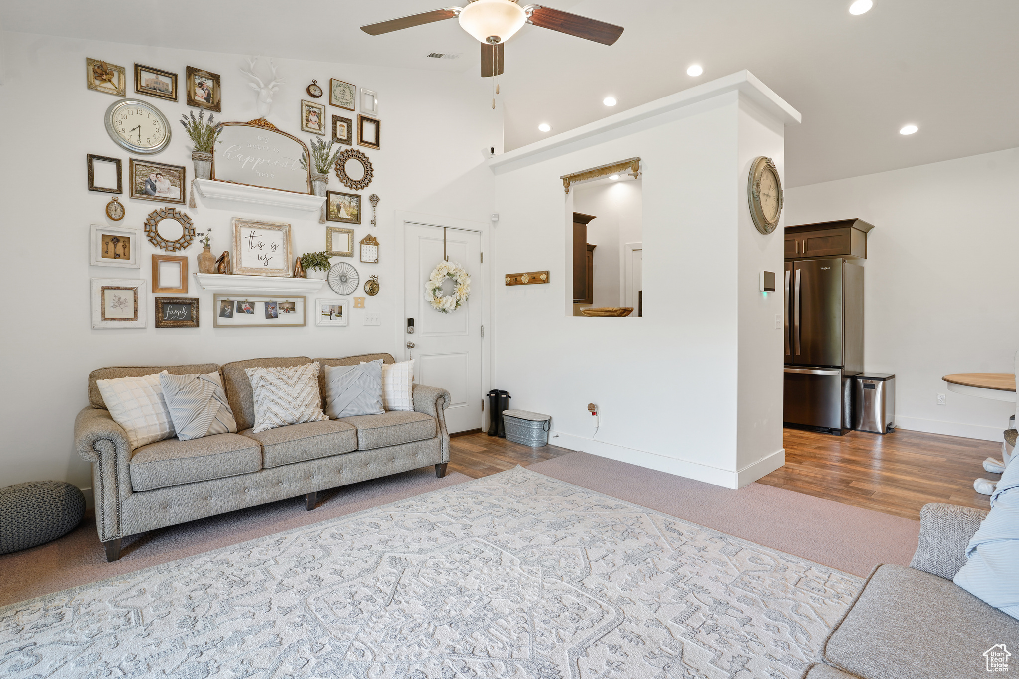 Living room with wood-type flooring, ceiling fan, and vaulted ceiling