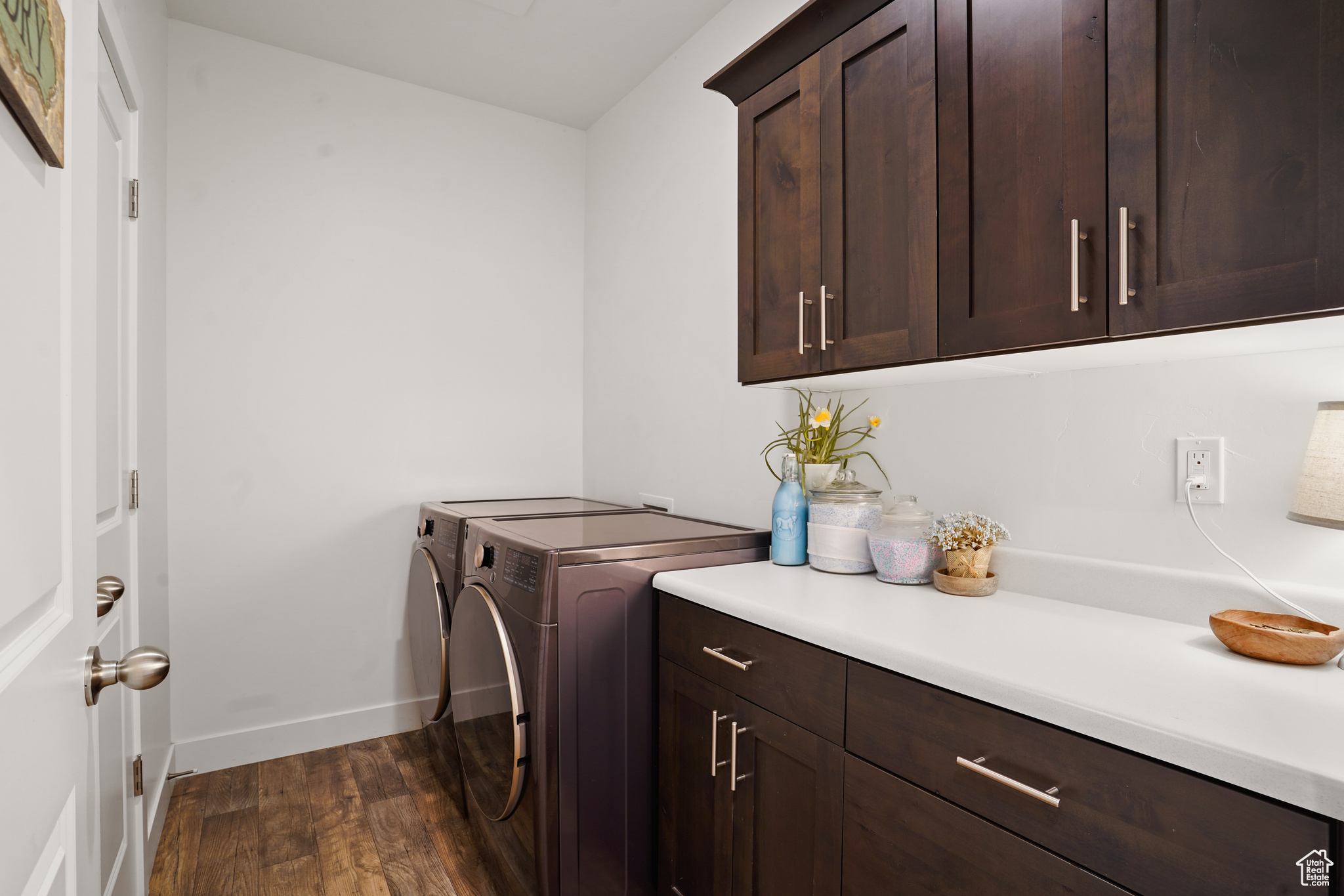 Laundry area with cabinets, dark wood-type flooring, and separate washer and dryer