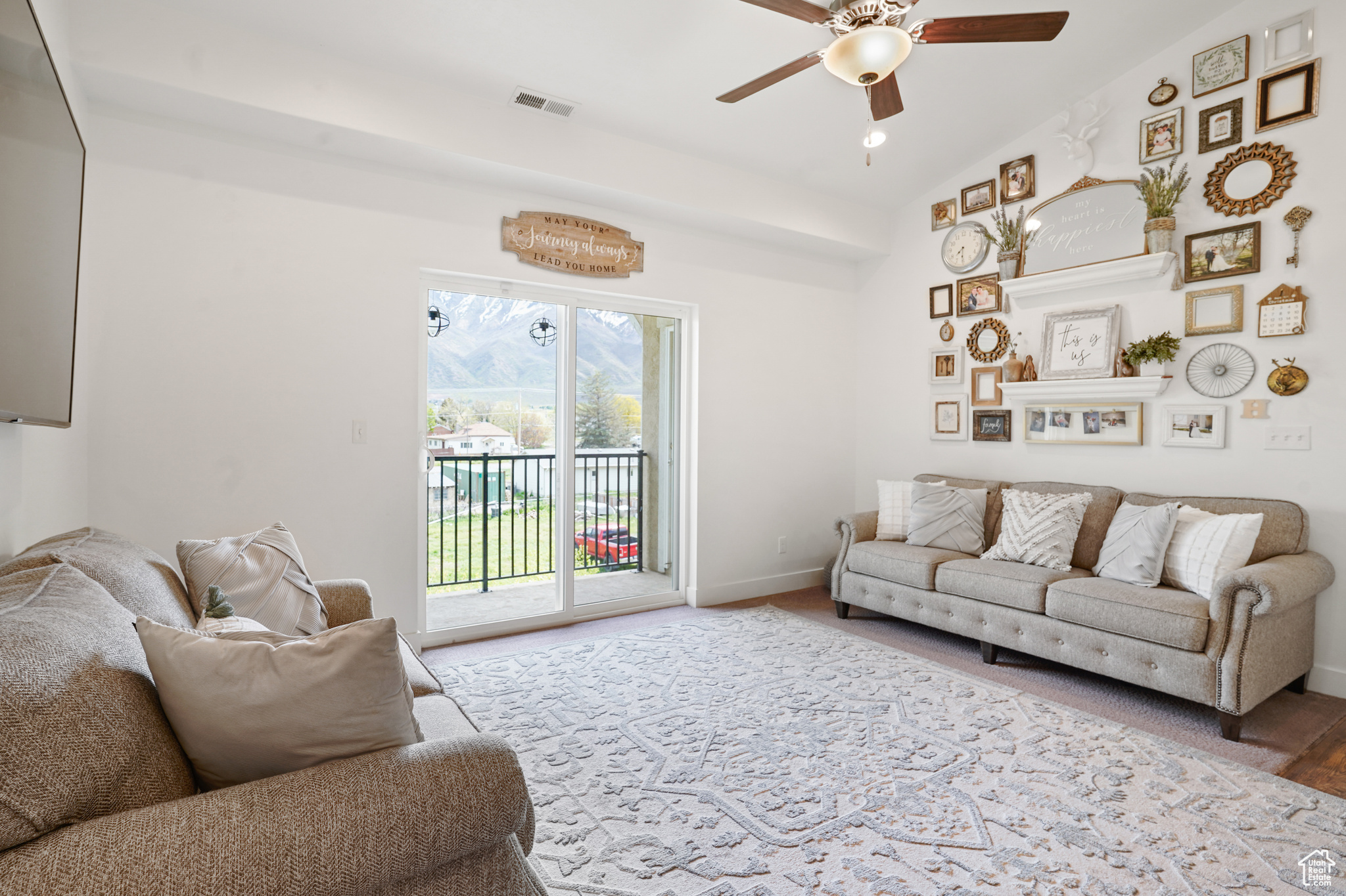 Living room featuring vaulted ceiling and ceiling fan