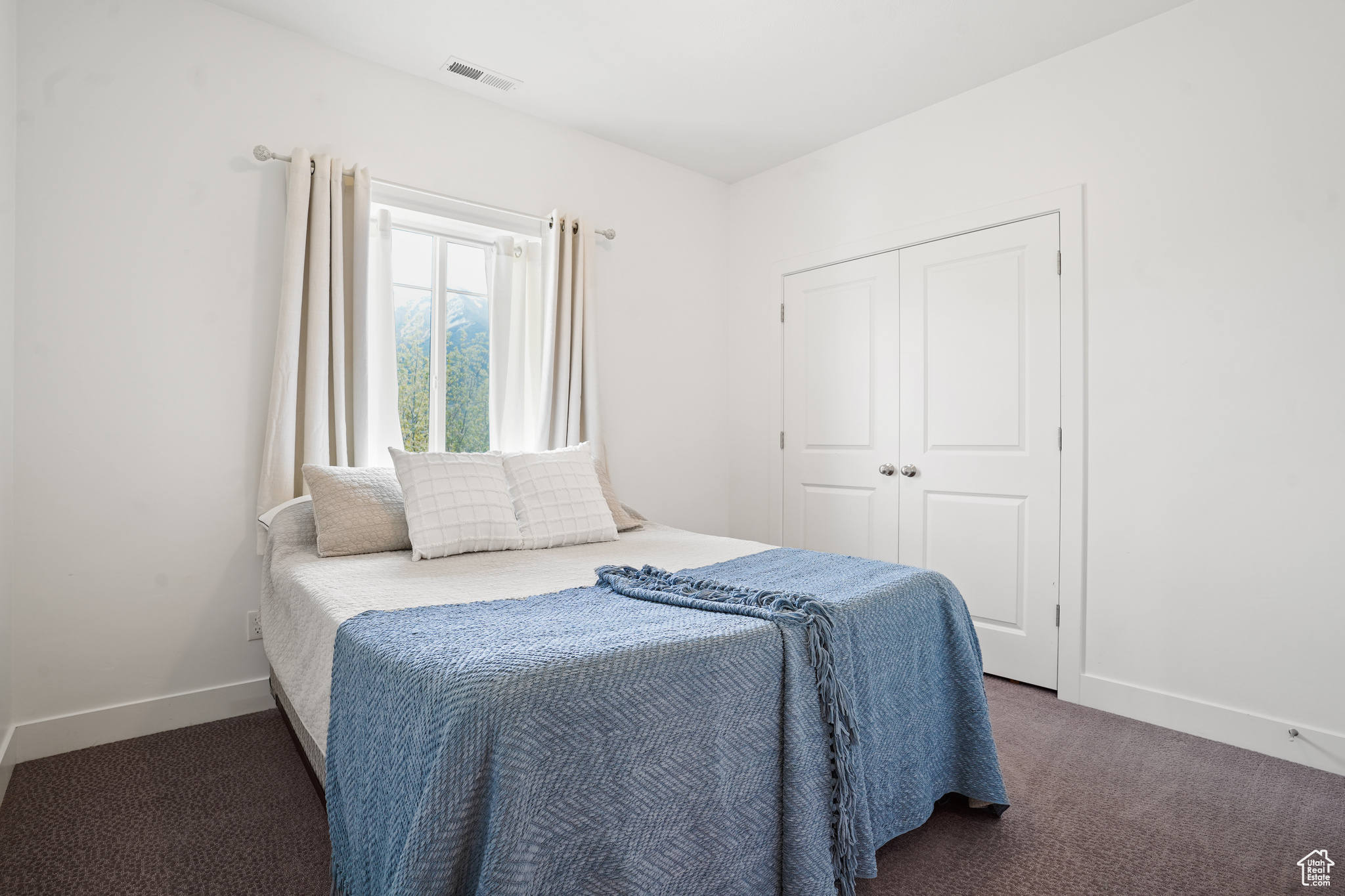 Bedroom featuring a closet and dark carpet