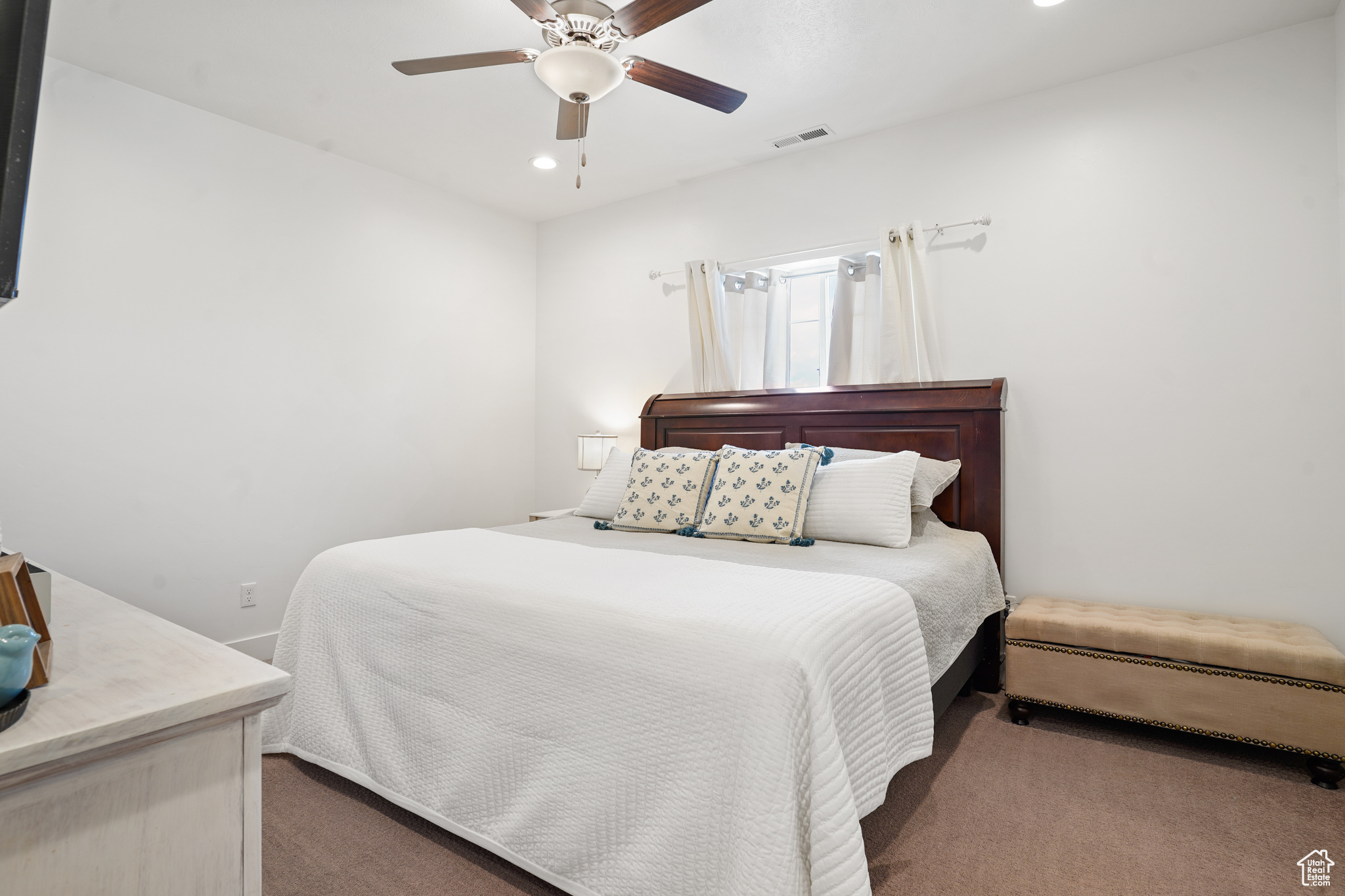 Carpeted bedroom featuring ceiling fan