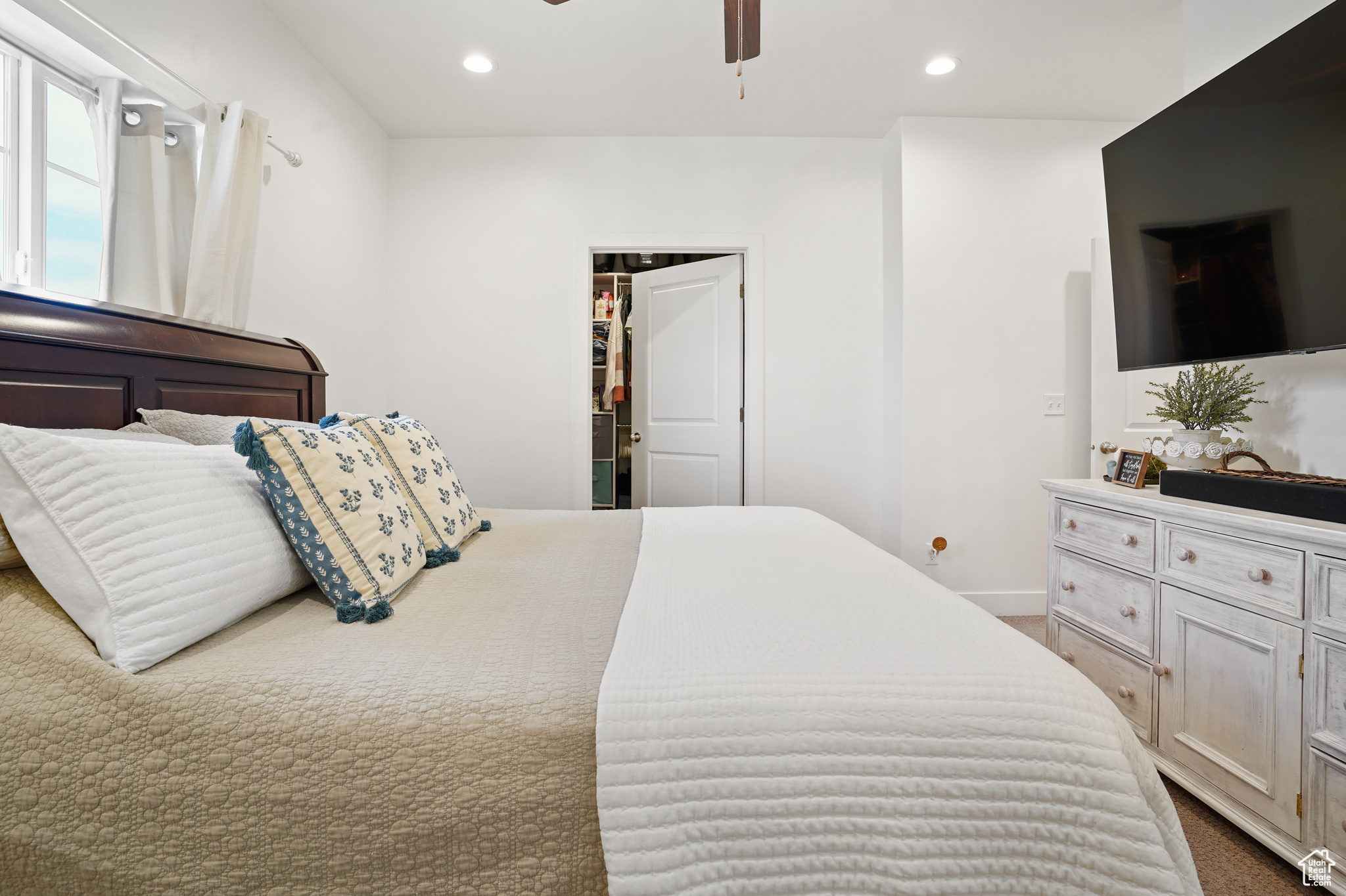 Bedroom featuring a closet, dark colored carpet, and ceiling fan