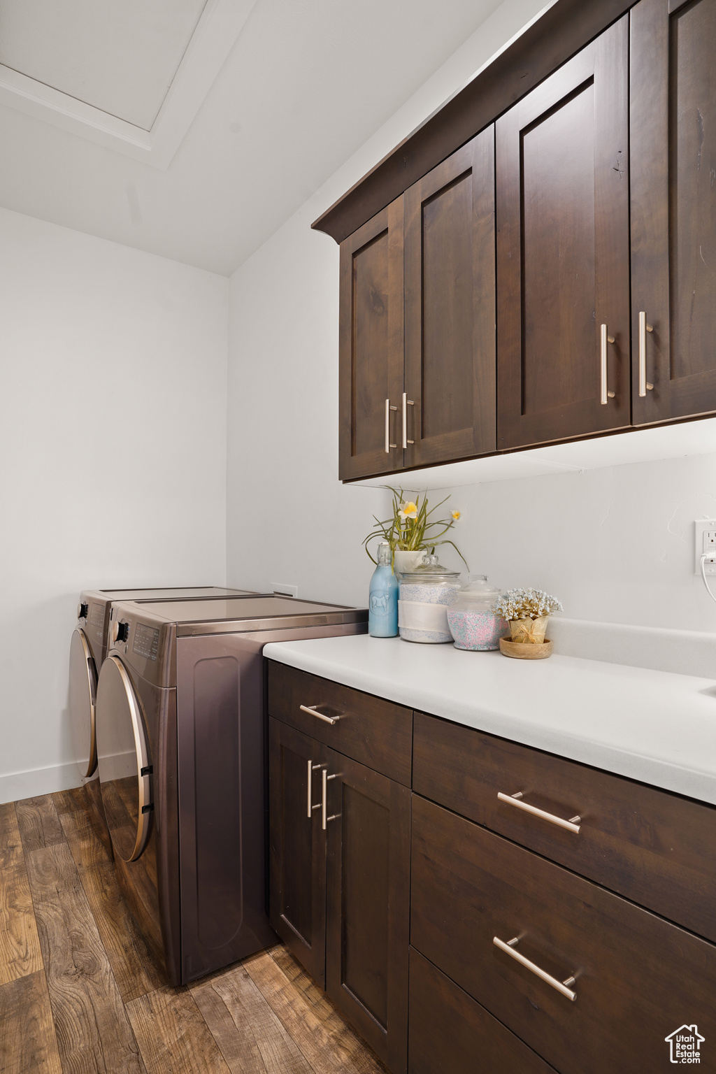 Laundry room featuring dark hardwood / wood-style flooring, cabinets, and separate washer and dryer