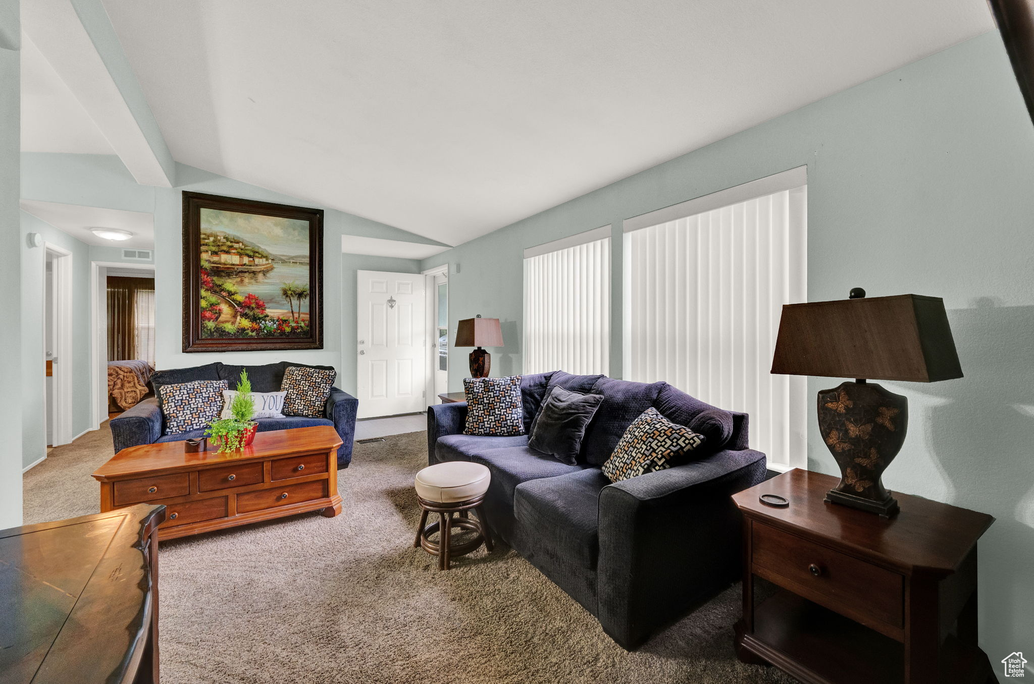 Carpeted living room featuring vaulted ceiling