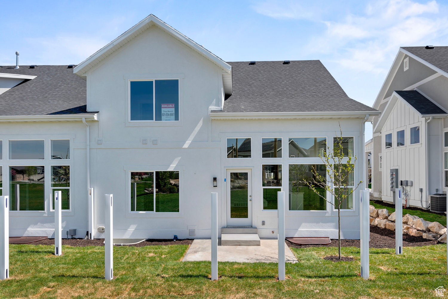 Rear view of house featuring a yard and central AC unit