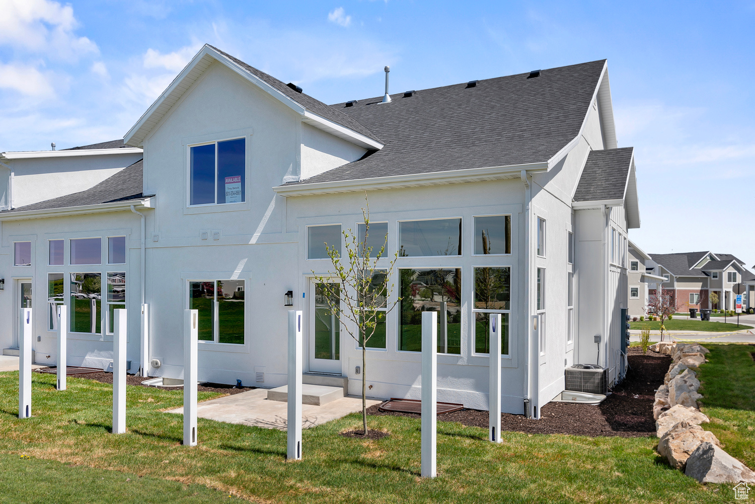 Rear view of property with central AC and a lawn