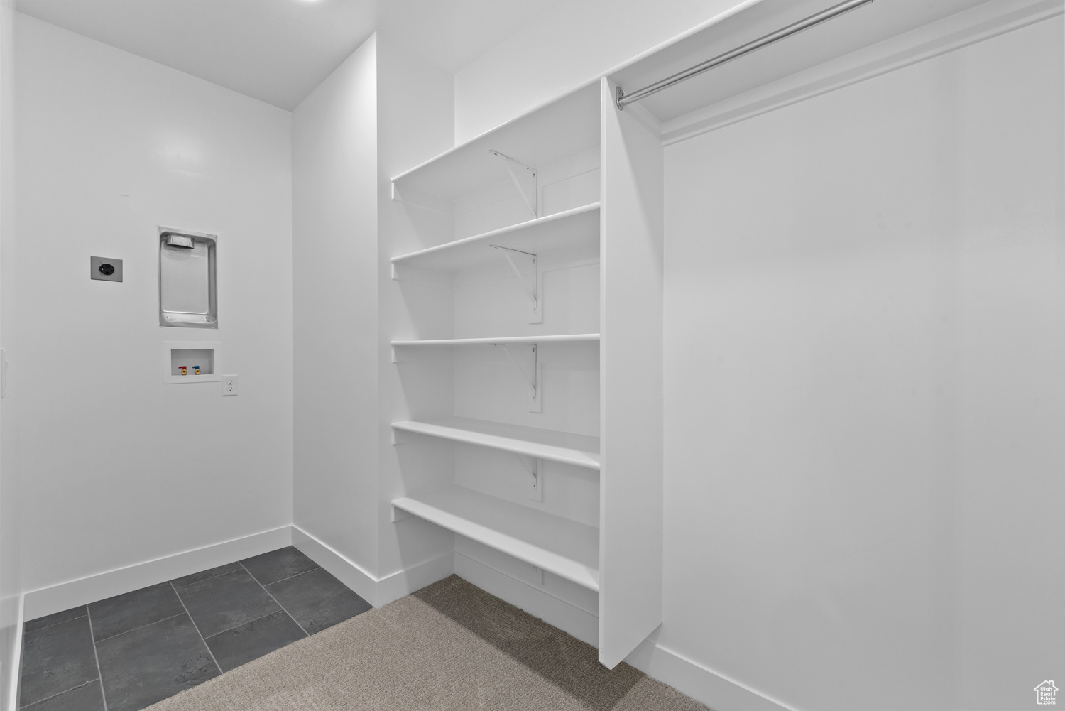 Spacious closet with dark tile floors