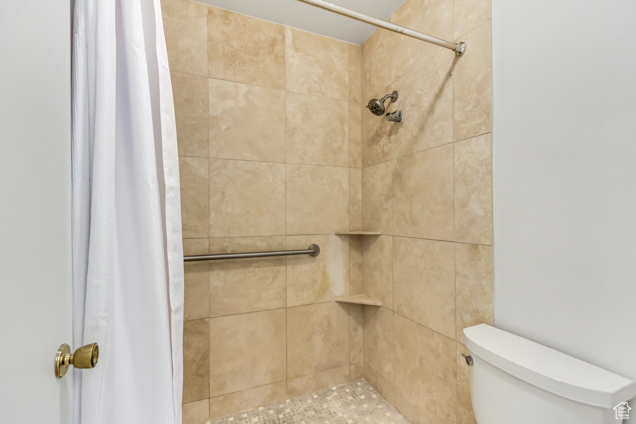 Bathroom with a shower with shower curtain and toilet