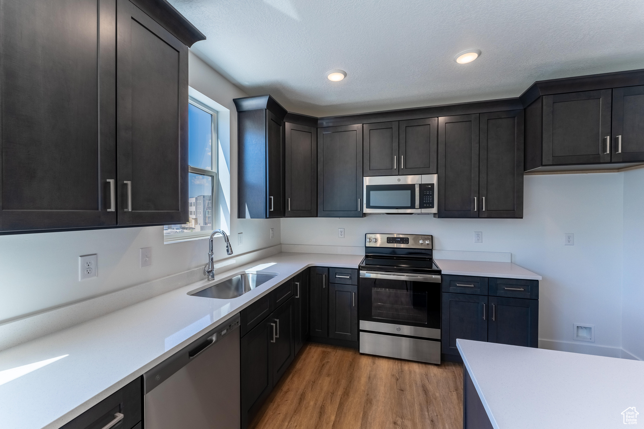 Kitchen featuring wood-type flooring, sink, and stainless steel appliances