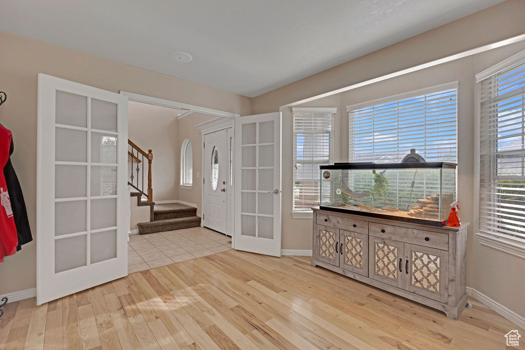 Entryway with a healthy amount of sunlight, french doors, and light tile floors