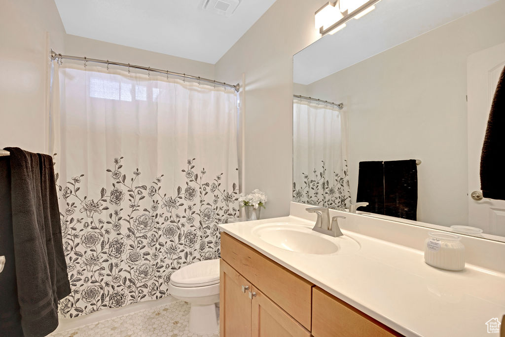 Bathroom featuring large vanity, toilet, and tile flooring
