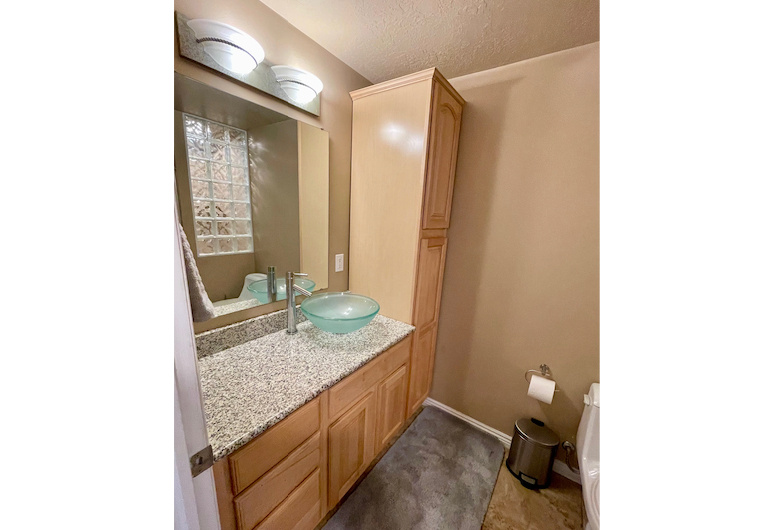 Bathroom featuring vanity with extensive cabinet space and a textured ceiling