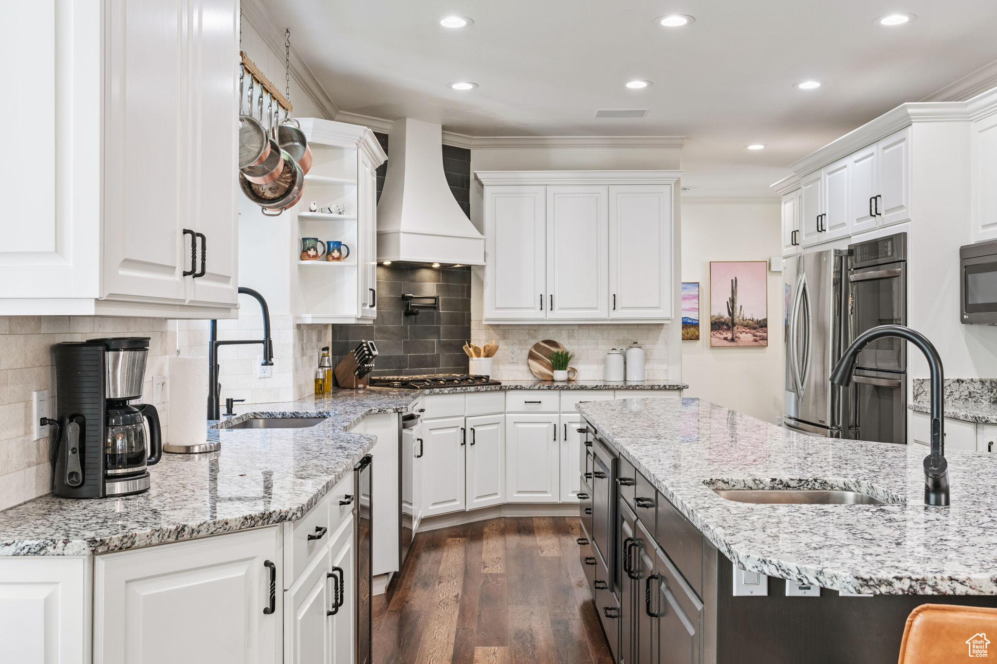 Kitchen featuring white cabinets, backsplash, custom exhaust hood, and dark wood-type flooring