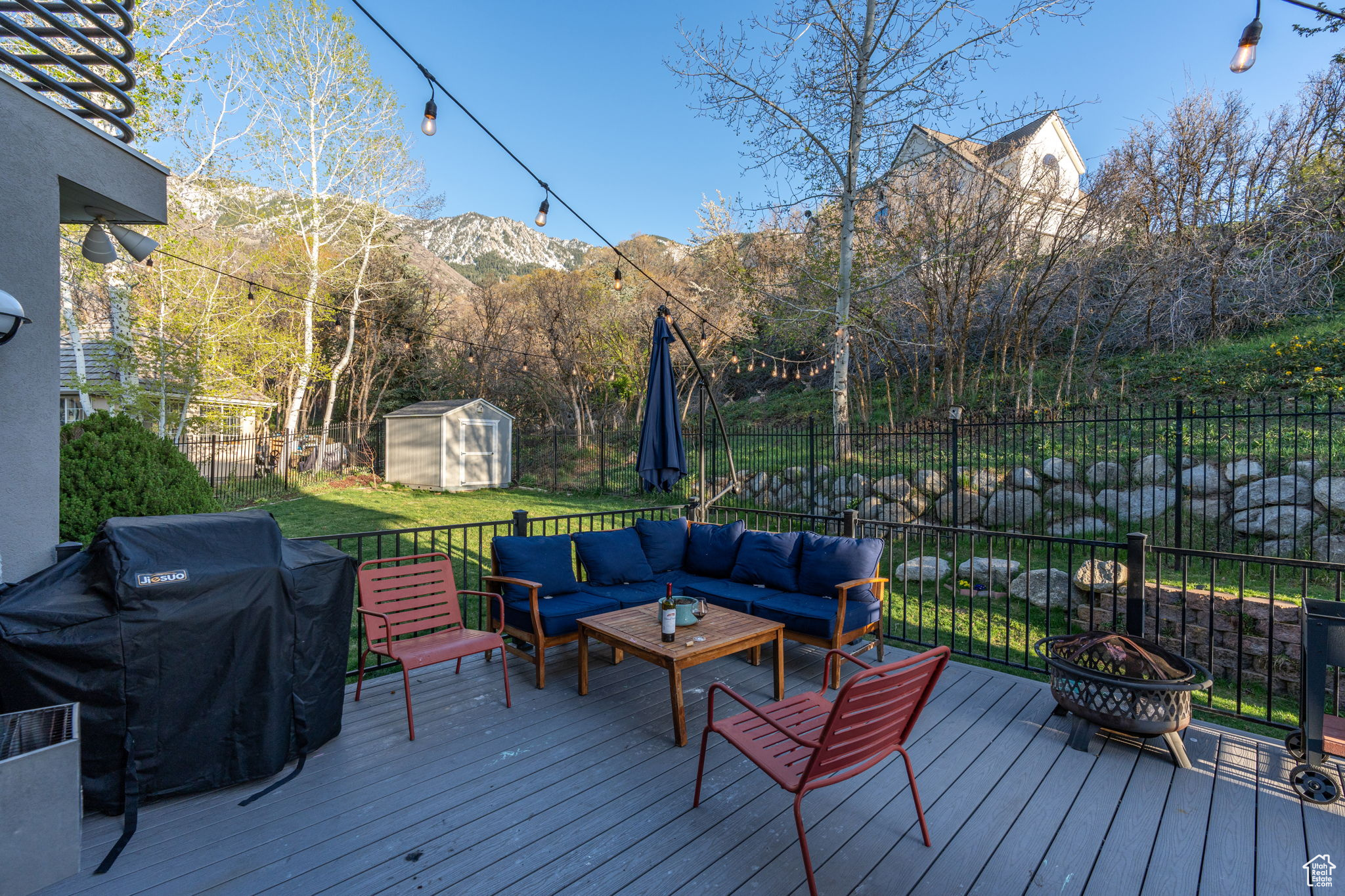 Deck featuring grilling area, an outdoor living space, a mountain view, and a storage shed