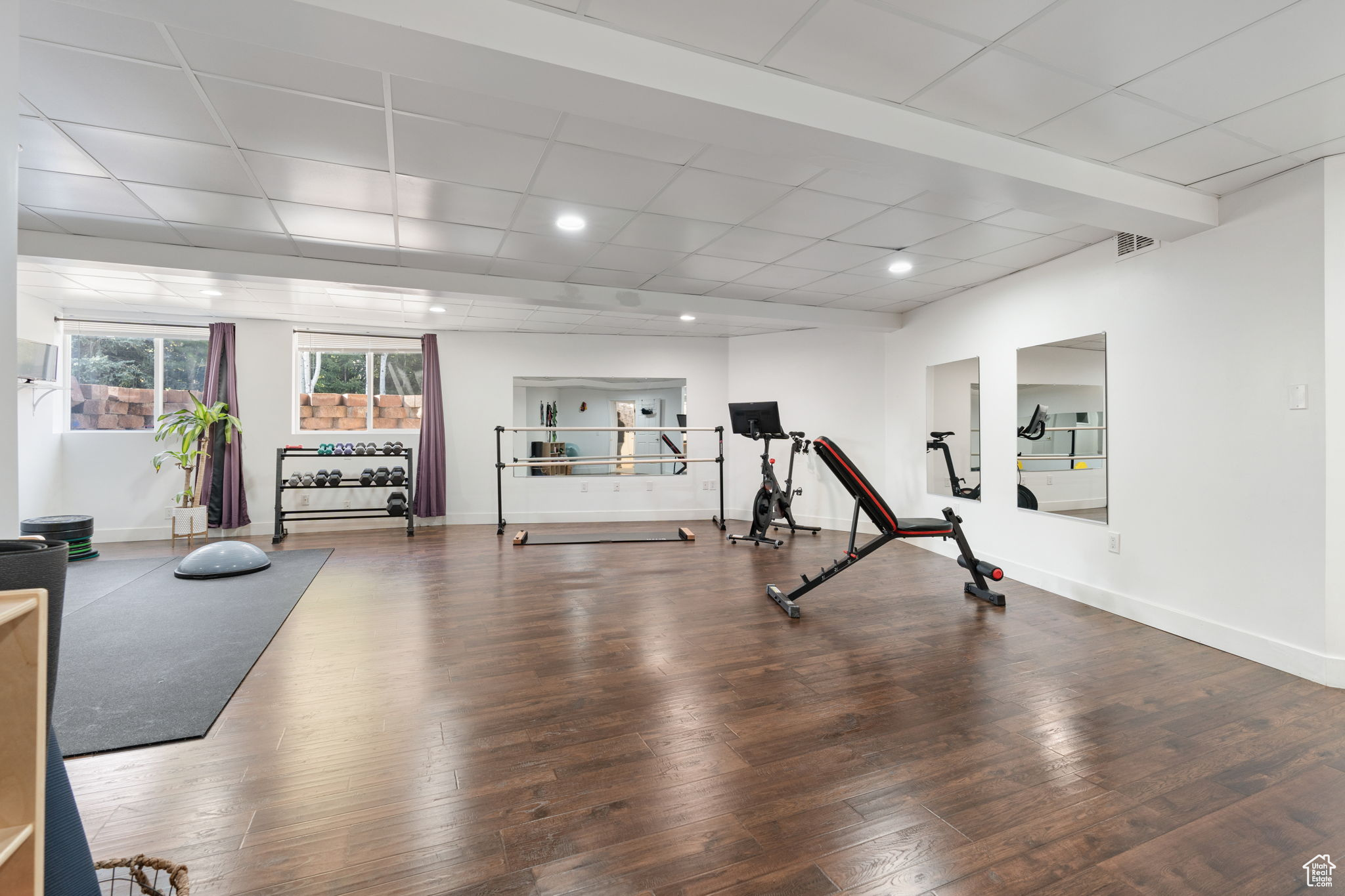 Workout room with a drop ceiling and hardwood / wood-style flooring