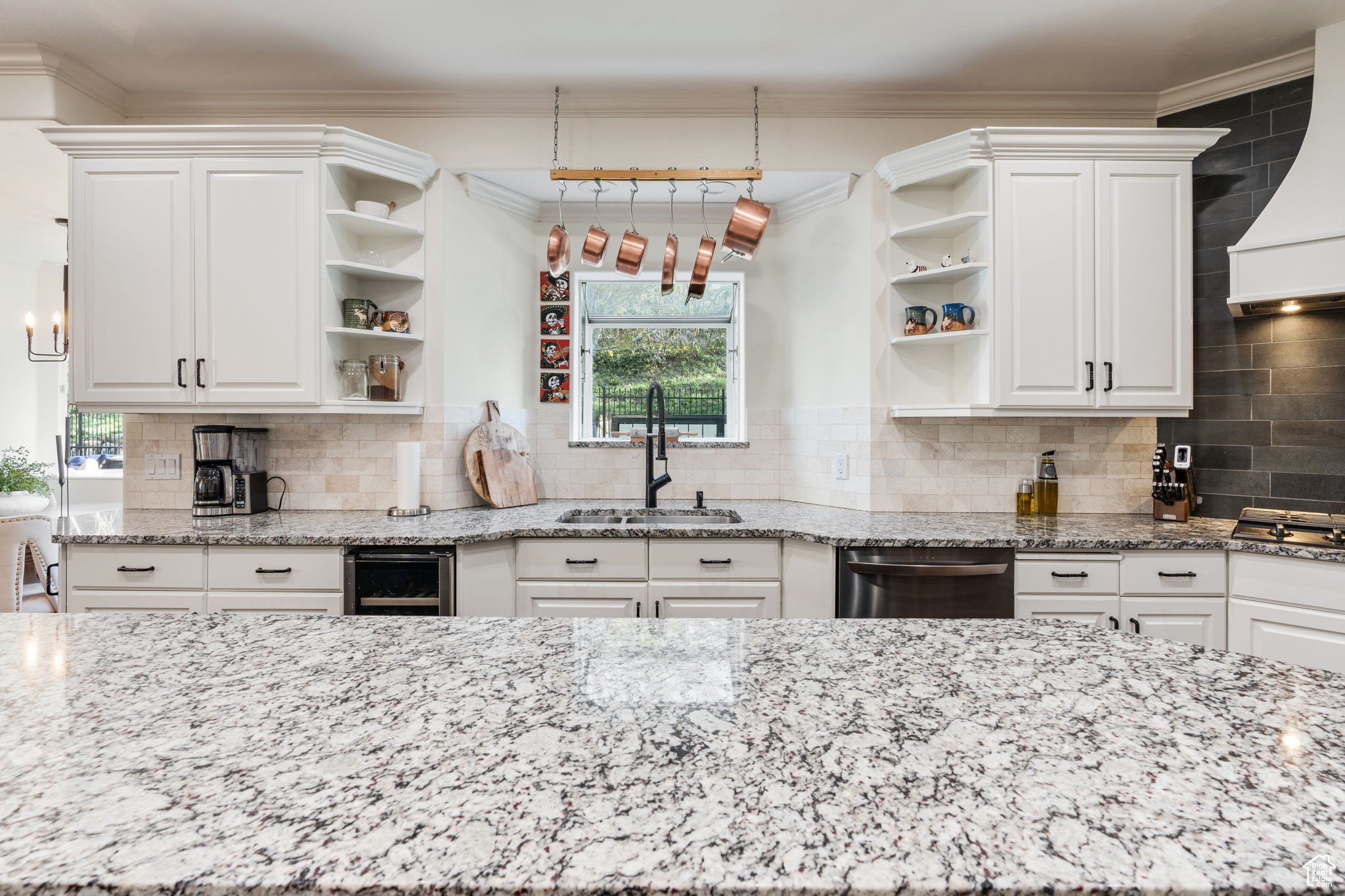 Kitchen featuring sink, tasteful backsplash, white cabinetry, and stainless steel appliances