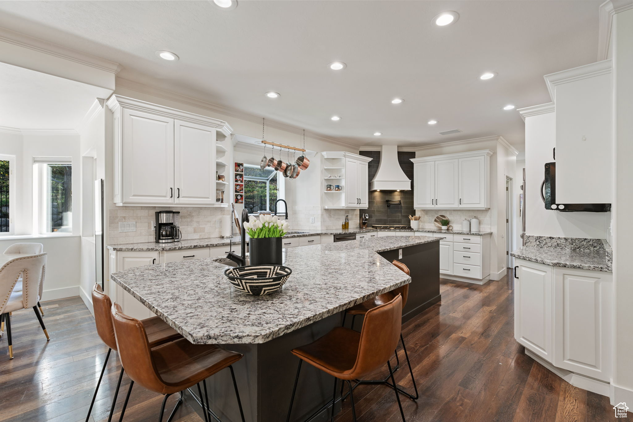 Kitchen with backsplash, premium range hood, white cabinetry, and dark hardwood / wood-style flooring