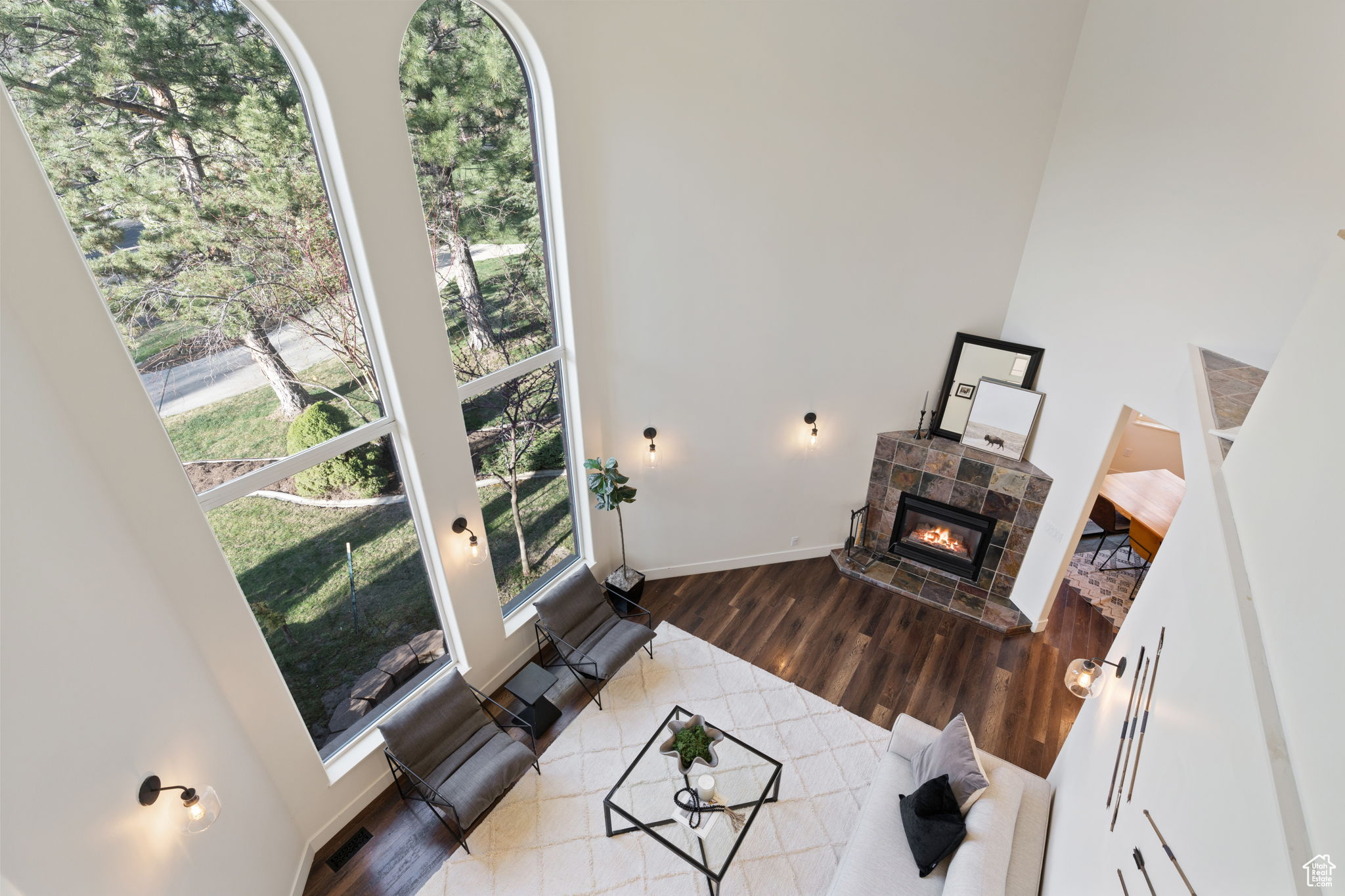 Living room featuring a towering ceiling, hardwood / wood-style flooring, and a tiled fireplace
