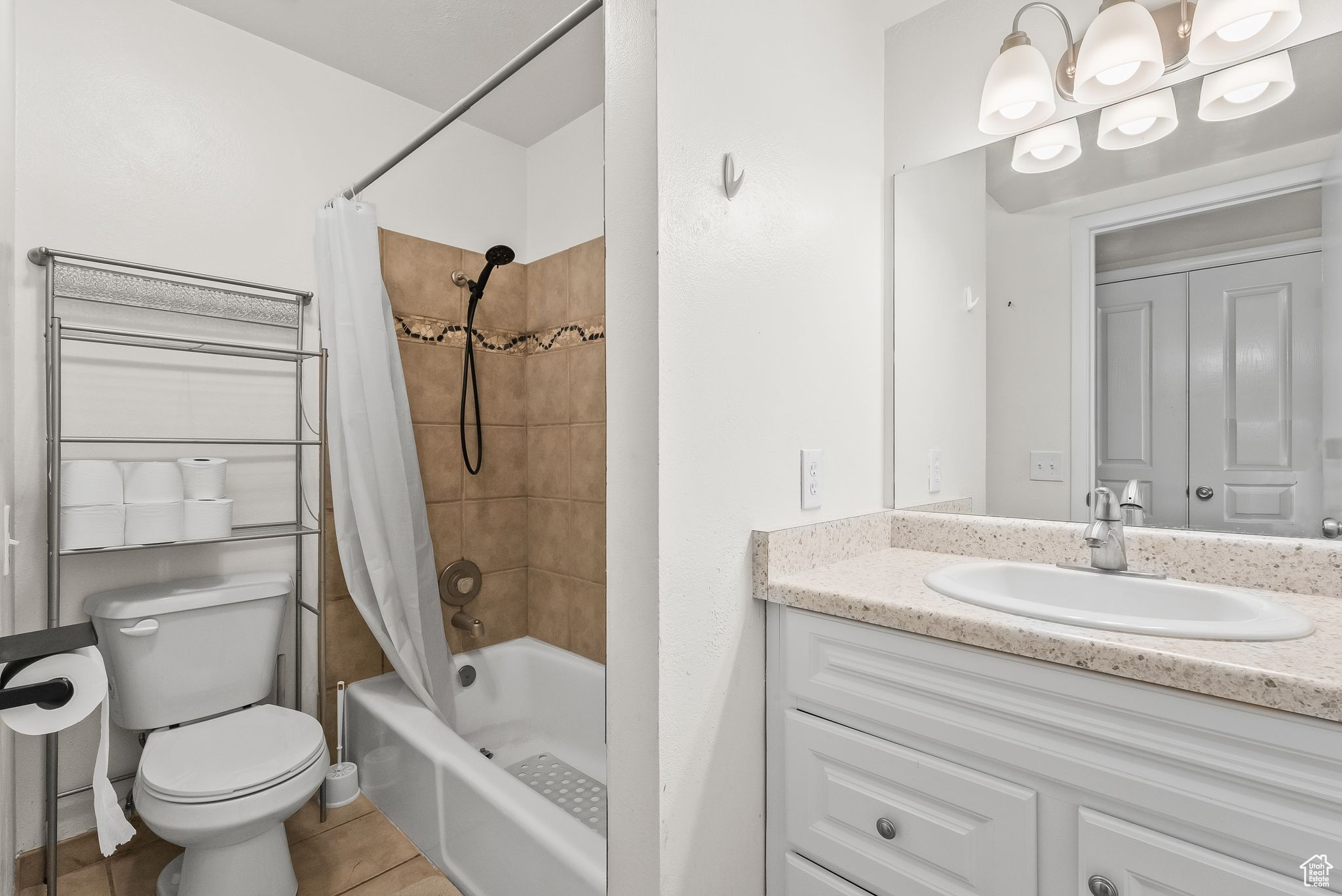 Full bathroom with shower / tub combo with curtain, vanity, tile floors, and toilet