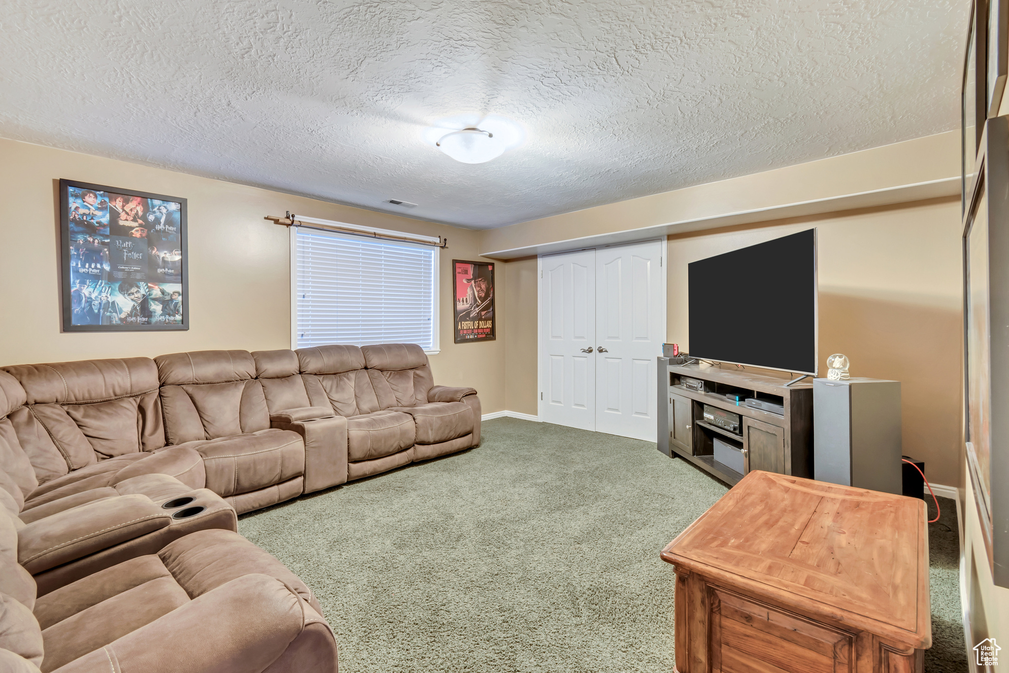 Carpeted Media room featuring a textured ceiling. Can be a large bedroom.