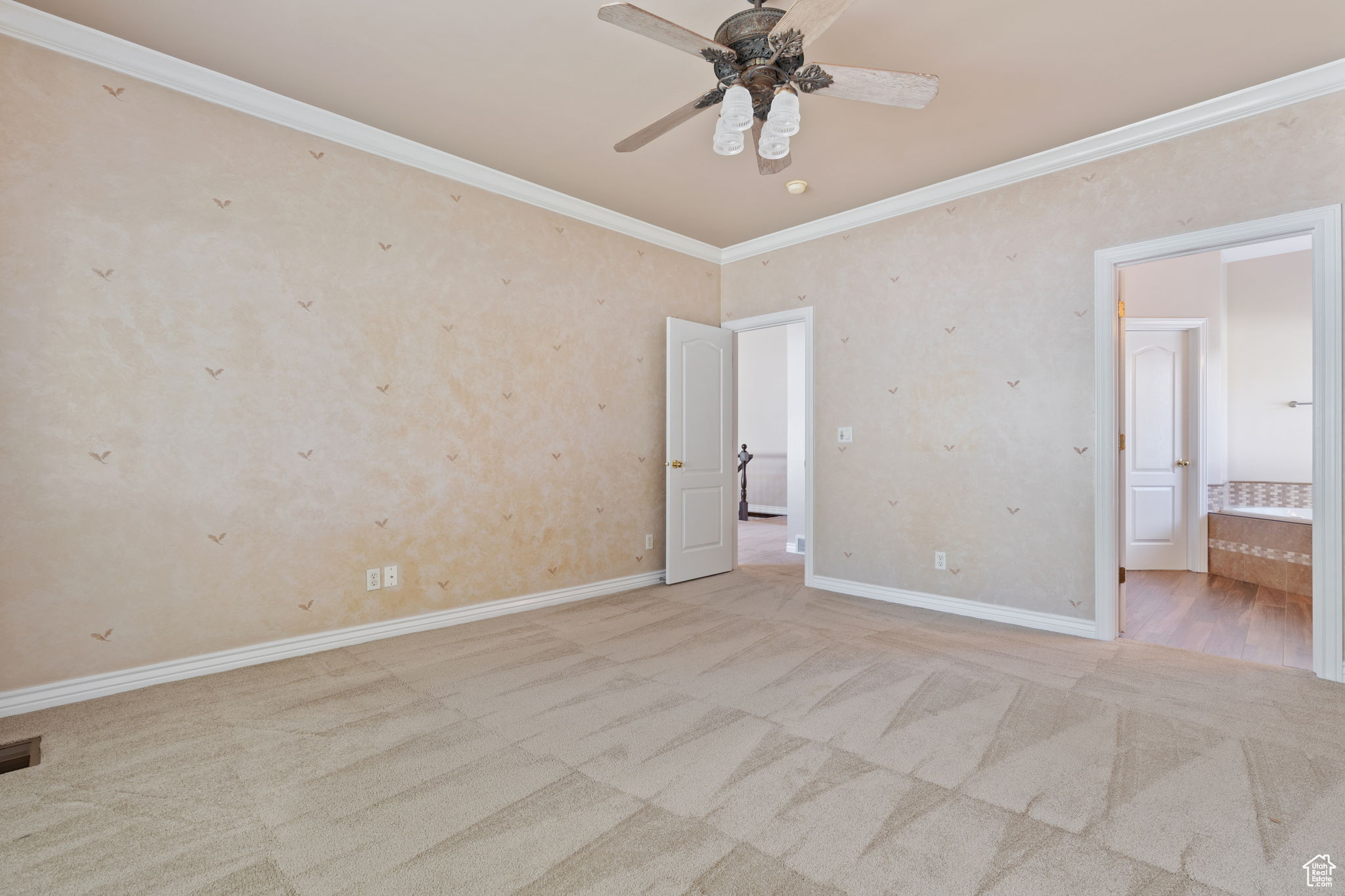 master bedroom with crown molding, light colored carpet, and ceiling fan
