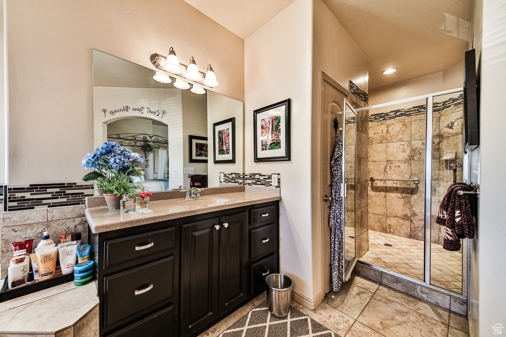 Bathroom featuring an enclosed shower, vanity, and tile floors