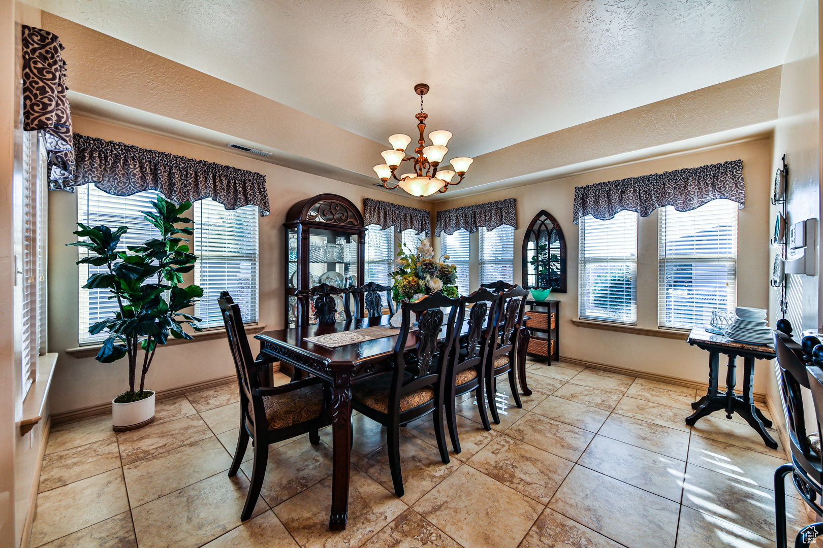 Dining room featuring plenty of natural light, a notable chandelier, and light tile floors