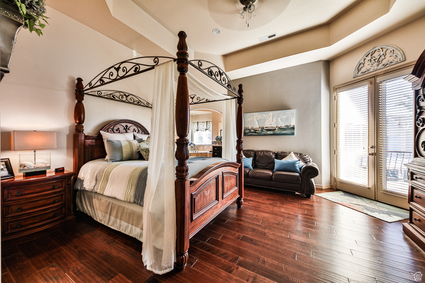 Bedroom with french doors, dark hardwood / wood-style flooring, access to outside, and a tray ceiling