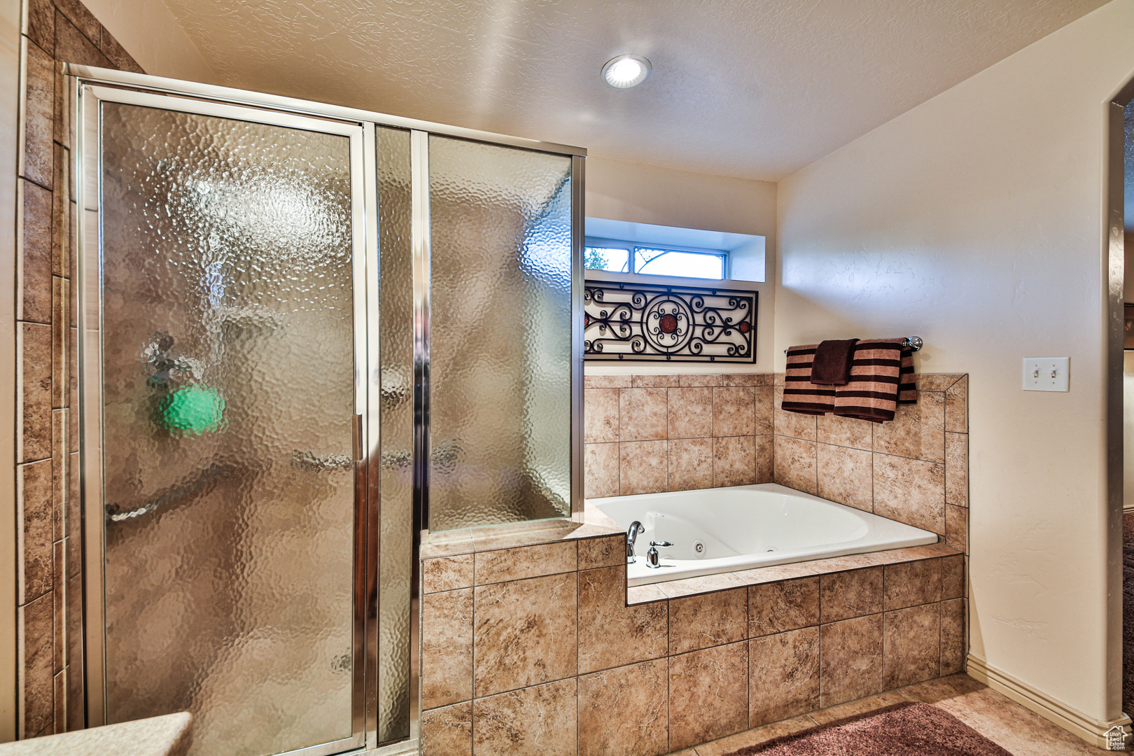 Bathroom with tile flooring and plus walk in shower